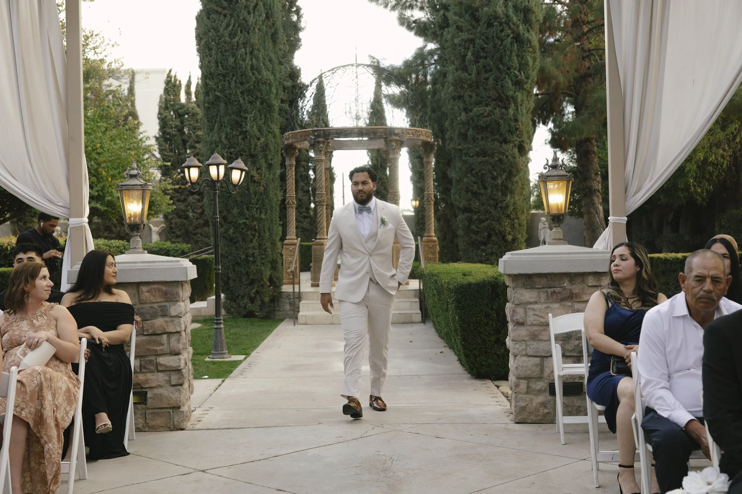 The wedding processional at Ashley Castle in Chandler, Arizona, was captured through hybrid film and digital photography, preserving the graceful entrances of the bridal party as they made their way through the romantic outdoor ceremony space surroun