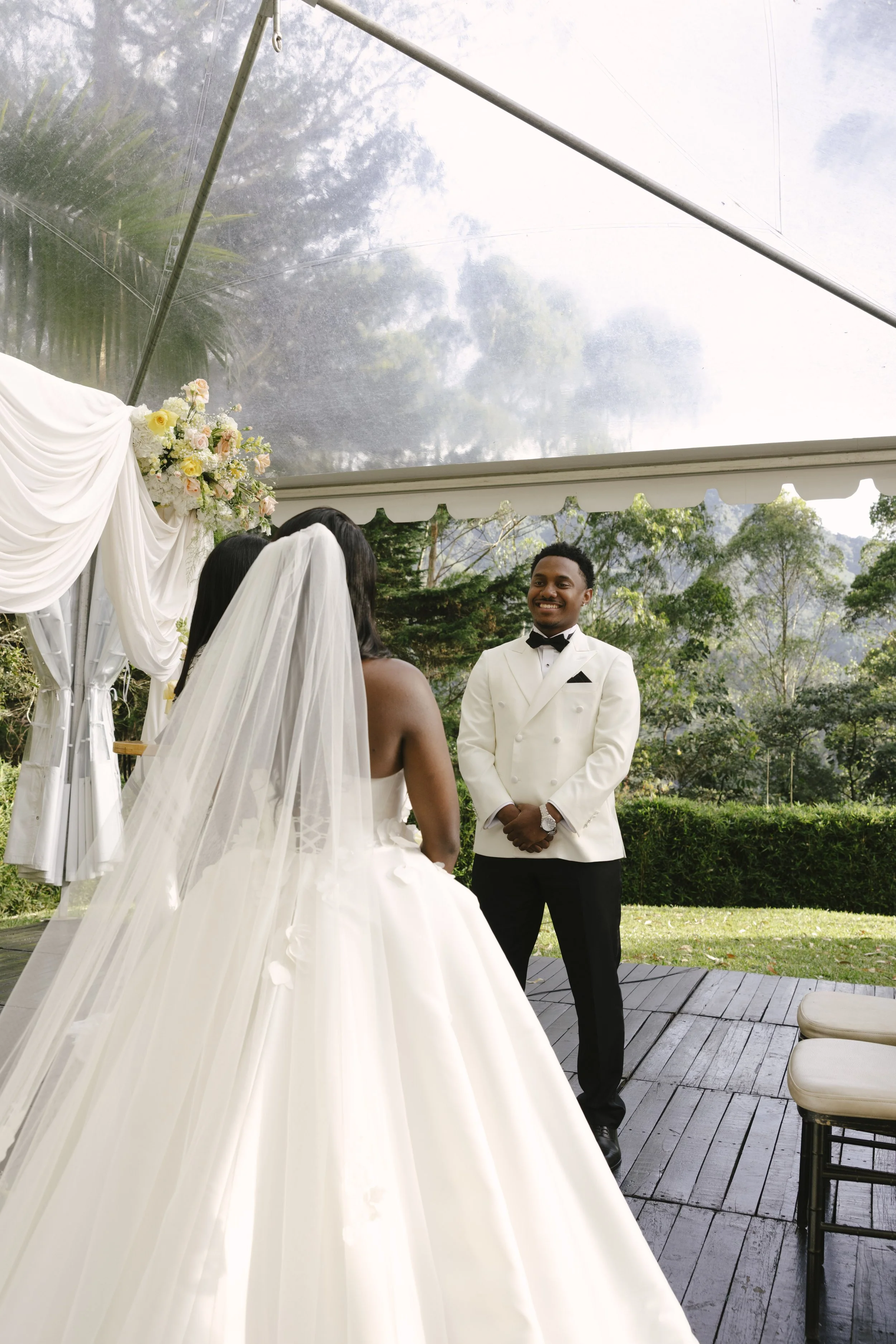 Forest Campestre wedding ceremony in Medellín, Colombia featuring the bridal processional, groom's reaction, emotional ceremony moments, floral aisle design, wedding guests, and documentary-style wedding photography