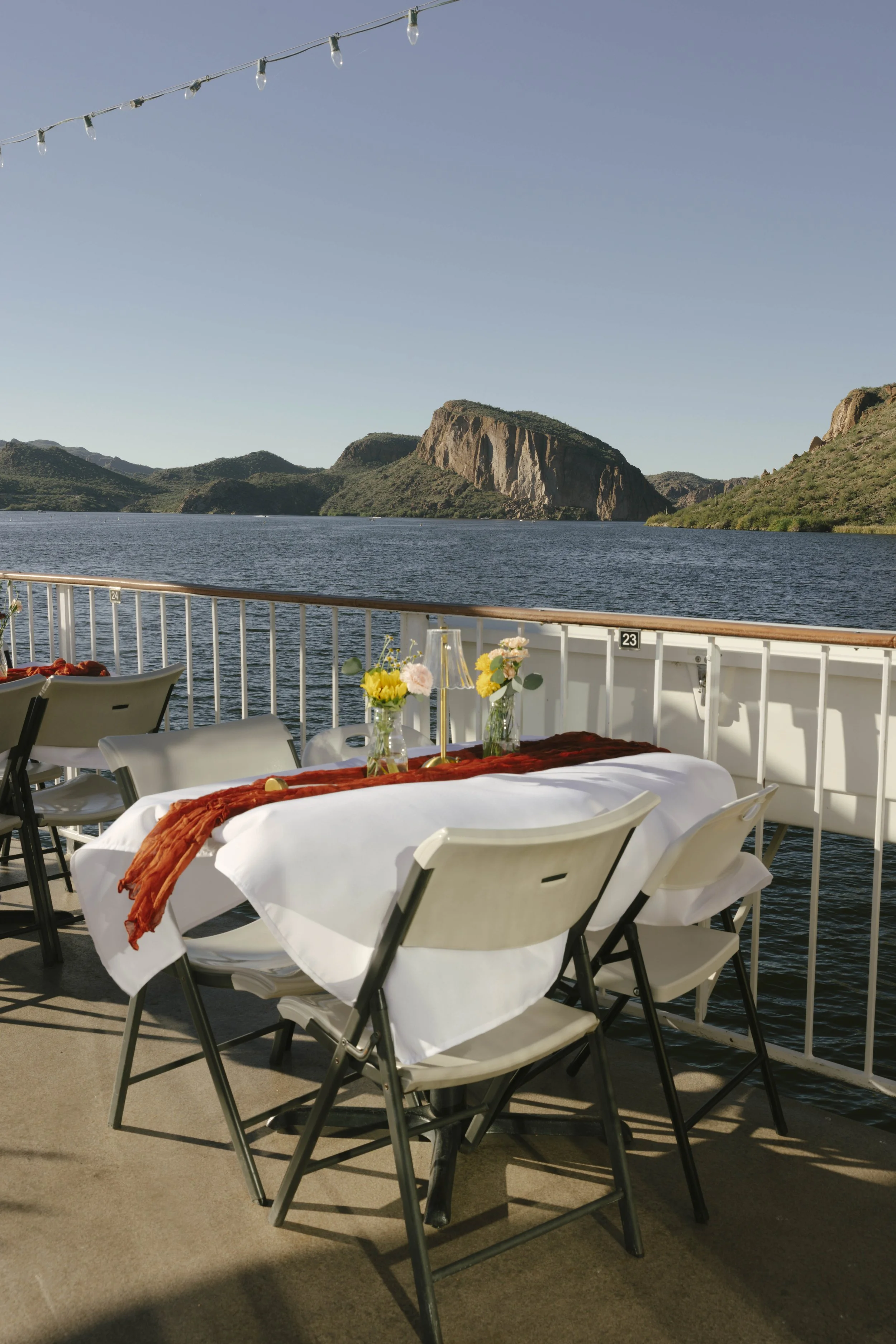 As the Dolly Steamboat cruised through Canyon Lake, guests enjoyed an intimate reception surrounded by Arizona’s desert mountains and open water. The tables were beautifully set with warm tones, fresh florals, and thoughtful details that complemented