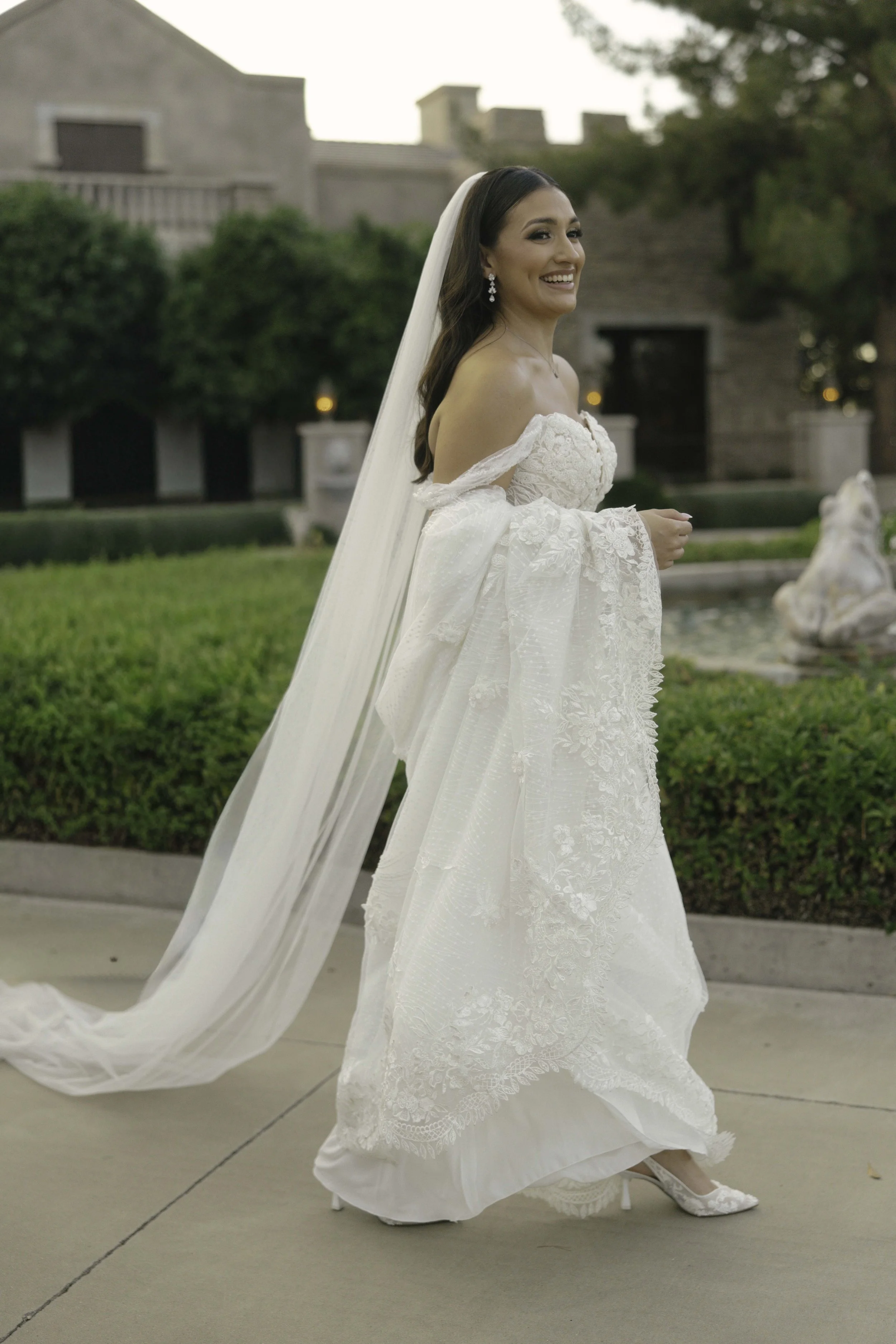 Bridal portraits at Ashley Castle in Chandler, Arizona, were captured through hybrid film and digital photography, showcasing the bride’s timeless elegance alongside her bridesmaids in the castle’s romantic courtyard gardens with soft evening light a