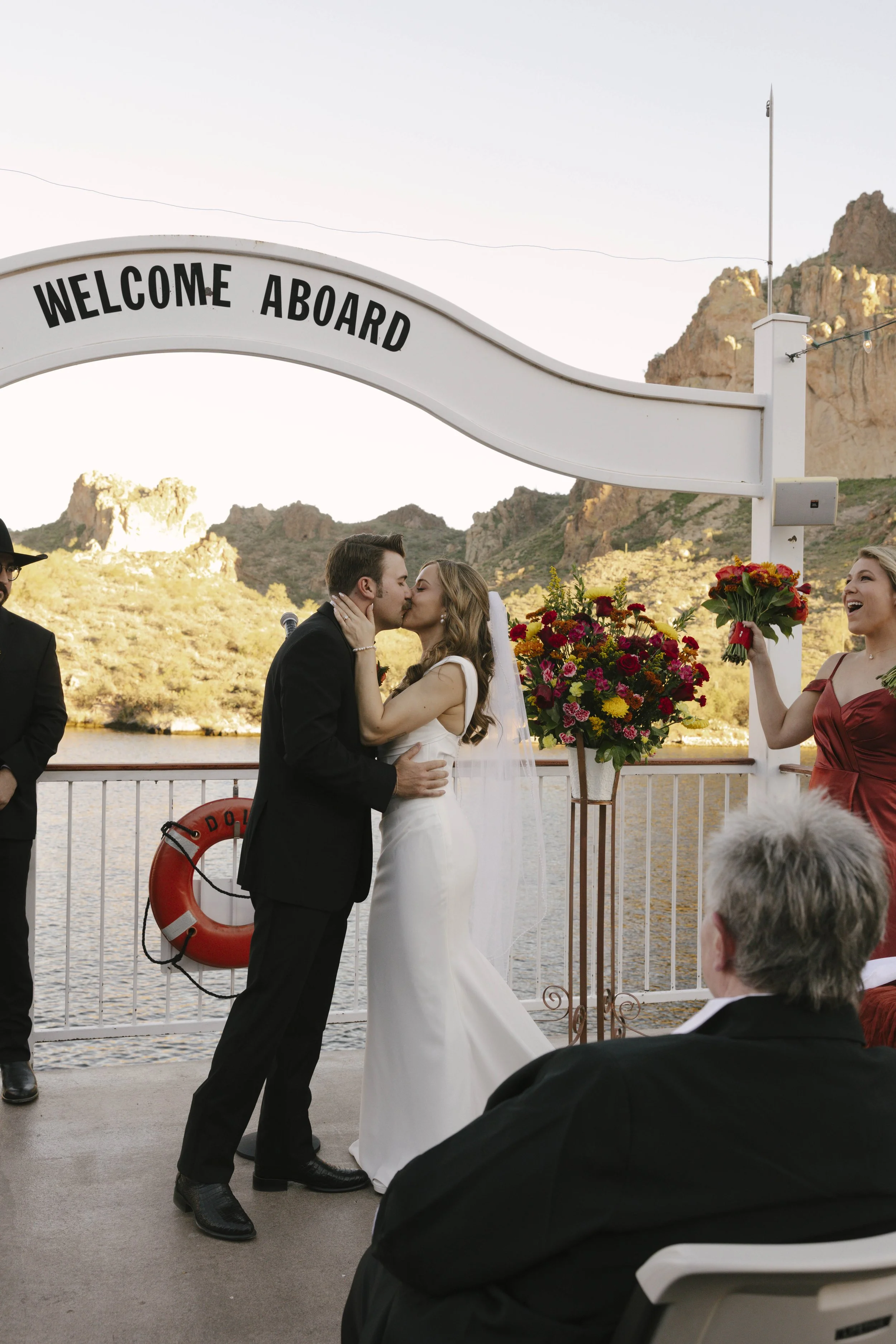 With Canyon Lake’s towering desert cliffs surrounding them, the couple exchanged rings and said “I do” aboard the Dolly Steamboat. Surrounded by about 60 of their closest friends and family, the ceremony took place on the deck with breathtaking Arizo