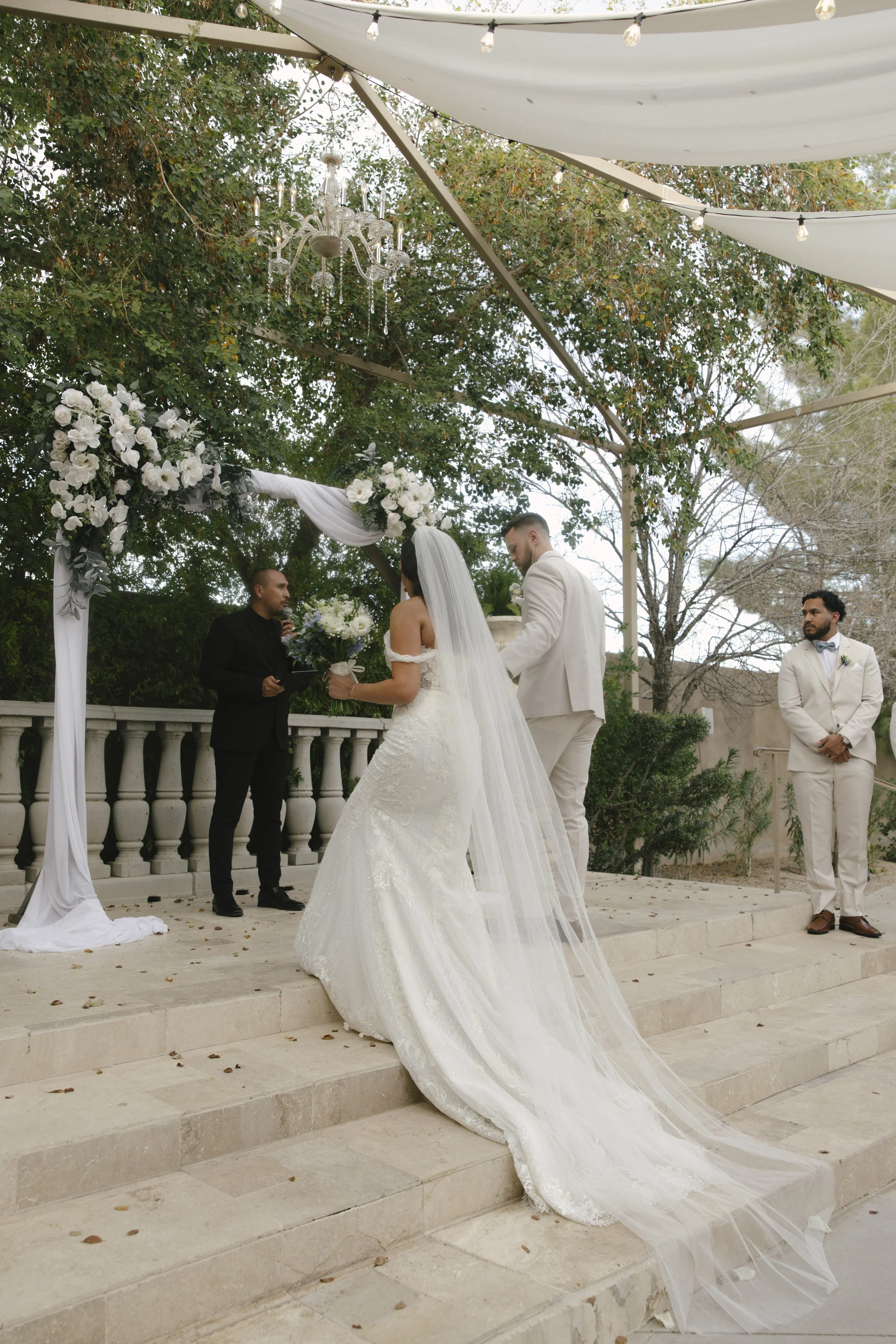 The wedding processional at Ashley Castle in Chandler, Arizona, was captured through hybrid film and digital photography, preserving the graceful entrances of the bridal party as they made their way through the romantic outdoor ceremony space surroun