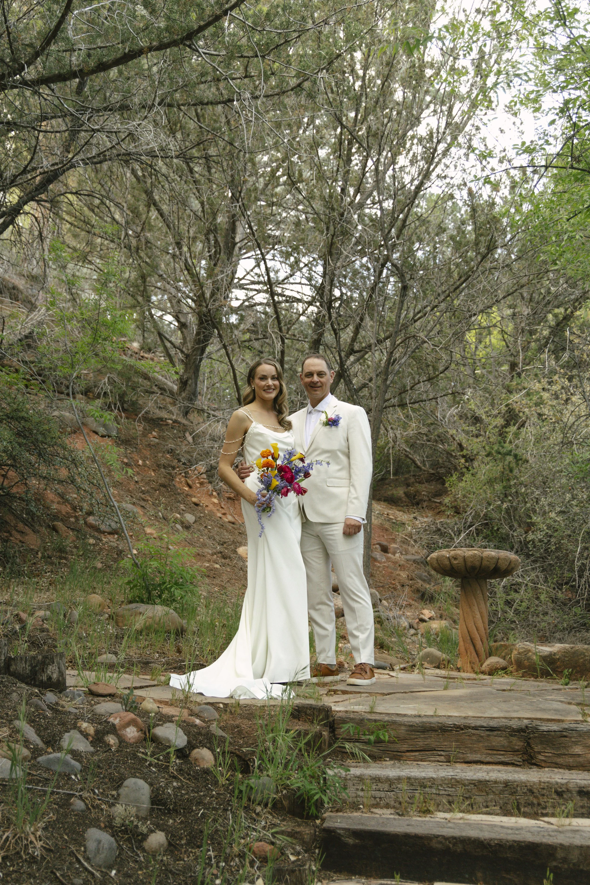 Chelsea and Travis shared an intimate first look surrounded by the natural beauty of Sedona before exchanging vows during their private Arizona elopement ceremony. Set along a peaceful garden path, these heartfelt moments marked the beginning of thei