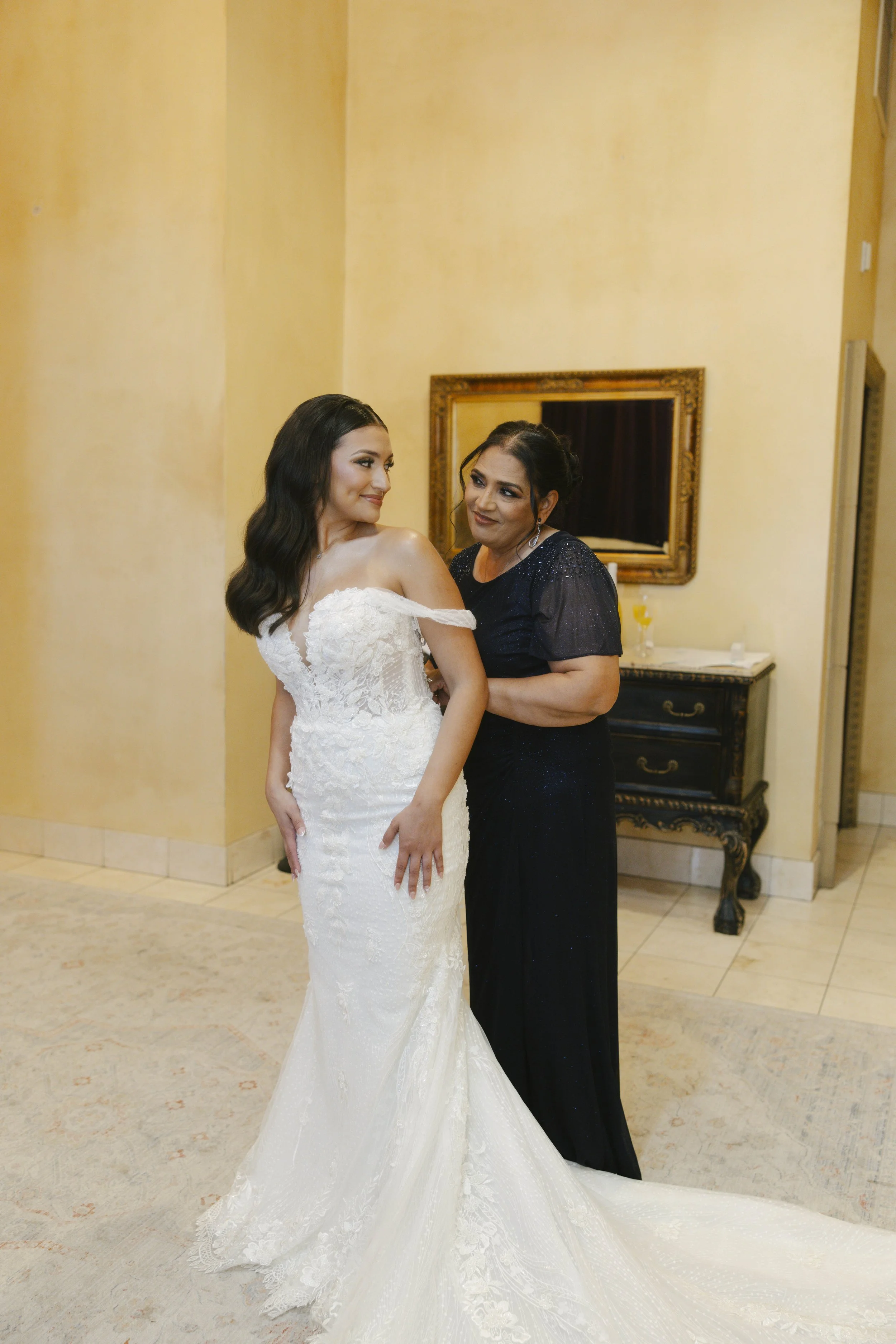 The bride’s final getting-ready moments at Ashley Castle in Chandler, Arizona, were captured through hybrid film and digital photography, preserving the intimate details of dress fastening, veil placement, and bridal finishing touches with timeless e