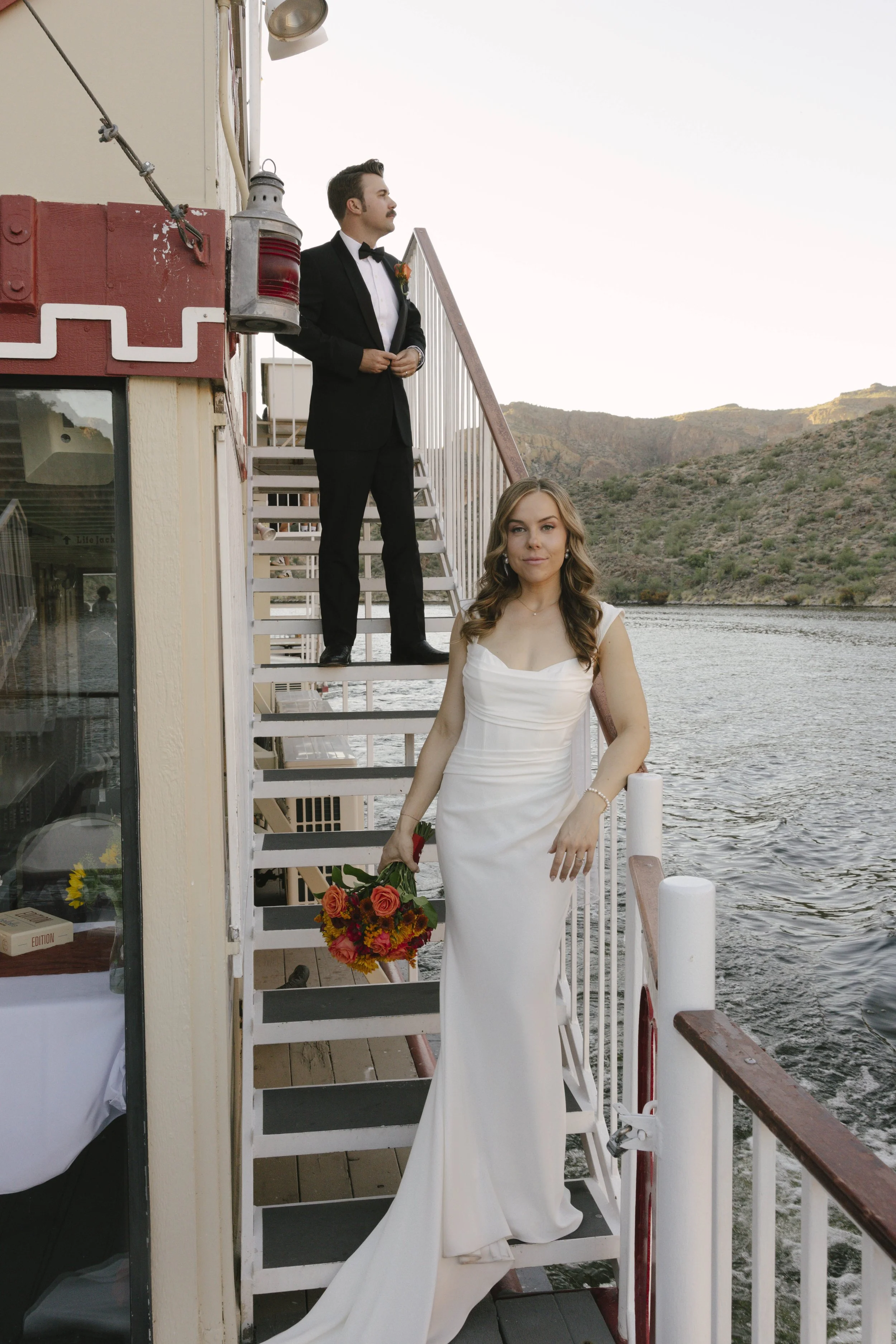 As the sun began to set over Canyon Lake, the couple stepped onto the deck of the Dolly Steamboat for golden hour portraits. With warm Arizona light reflecting off the water and desert mountains surrounding them, these quiet moments captured the beau