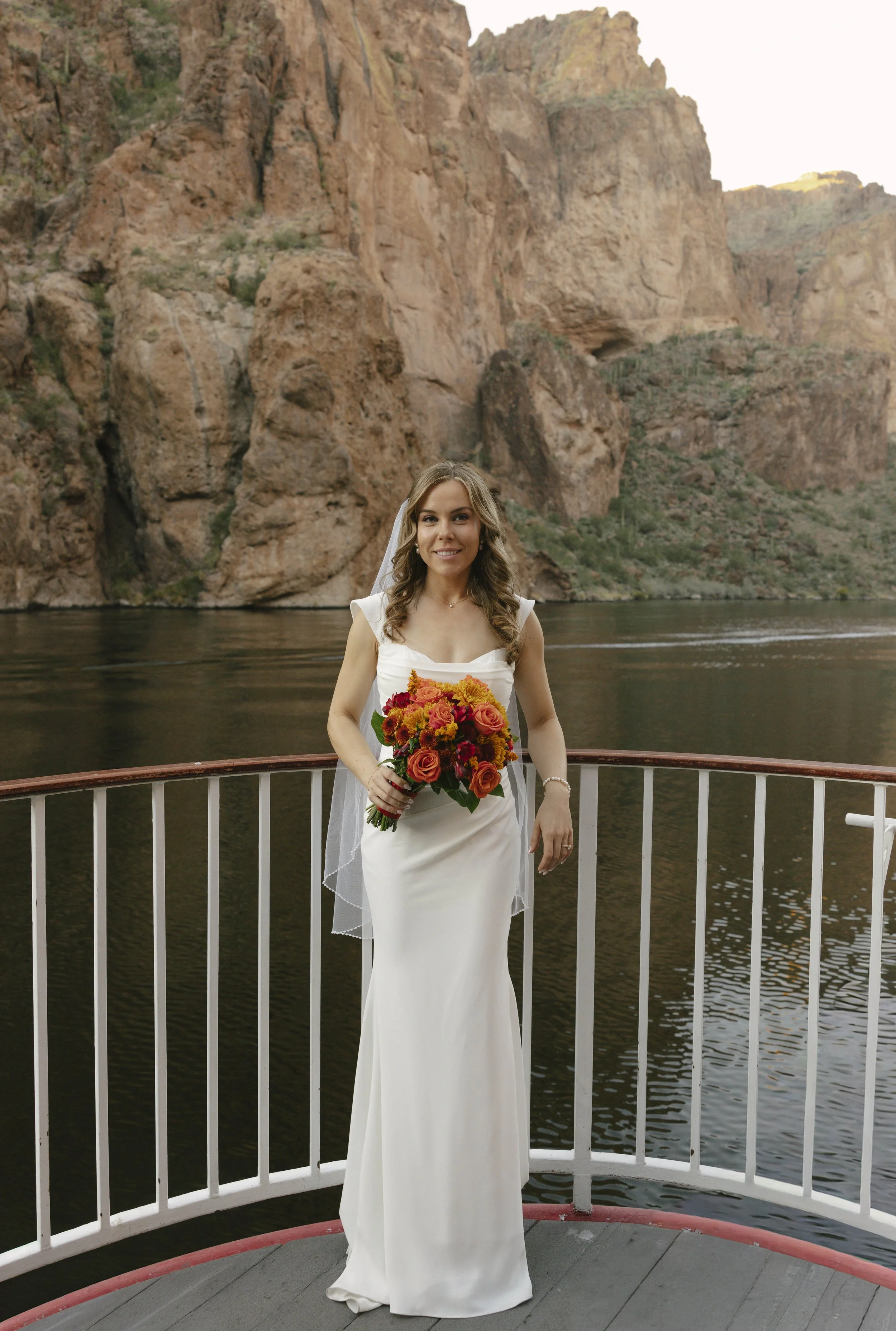 As the sun began to set over Canyon Lake, the couple stepped onto the deck of the Dolly Steamboat for golden hour portraits. With warm Arizona light reflecting off the water and desert mountains surrounding them, these quiet moments captured the beau