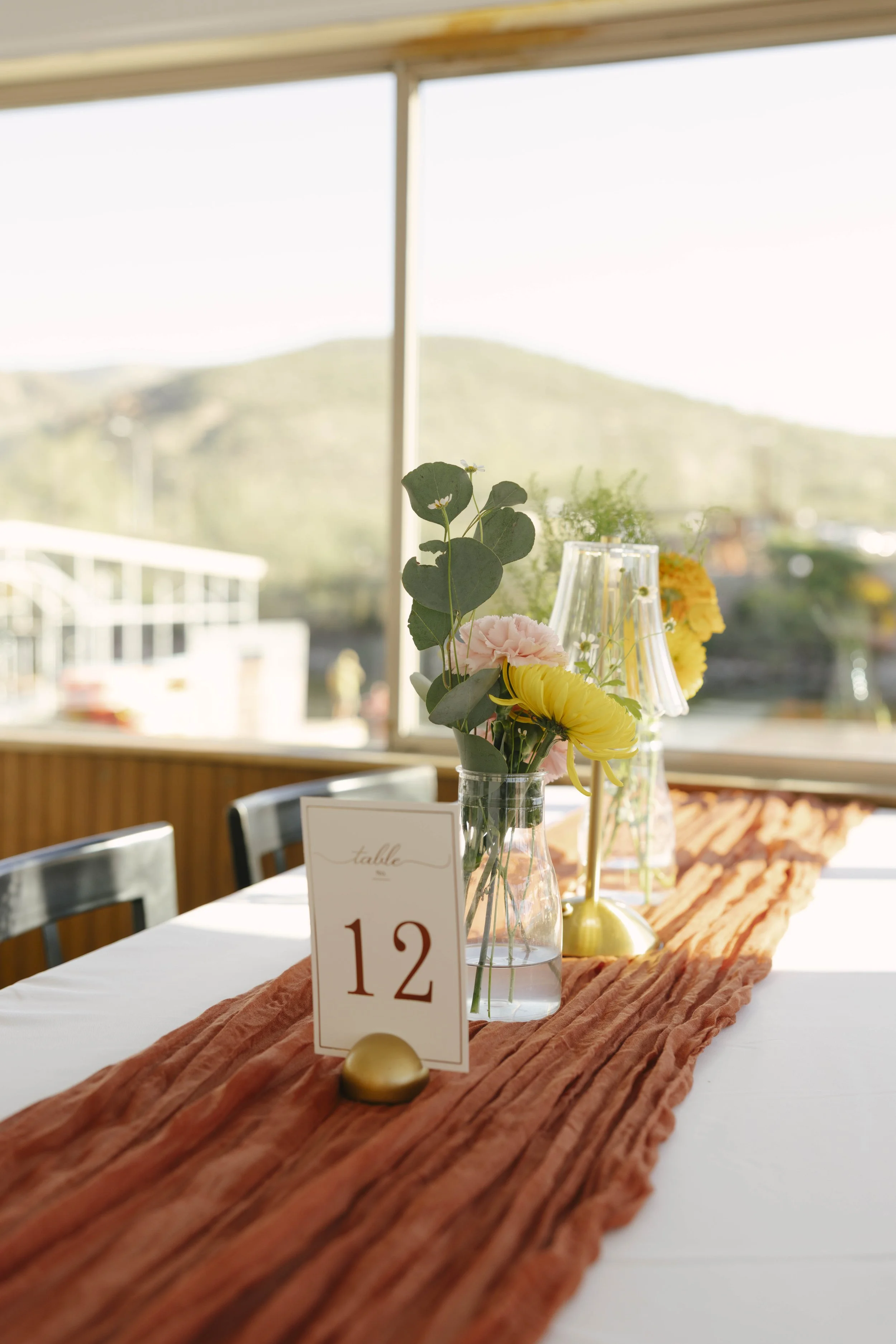 As the Dolly Steamboat cruised through Canyon Lake, guests enjoyed an intimate reception surrounded by Arizona’s desert mountains and open water. The tables were beautifully set with warm tones, fresh florals, and thoughtful details that complemented