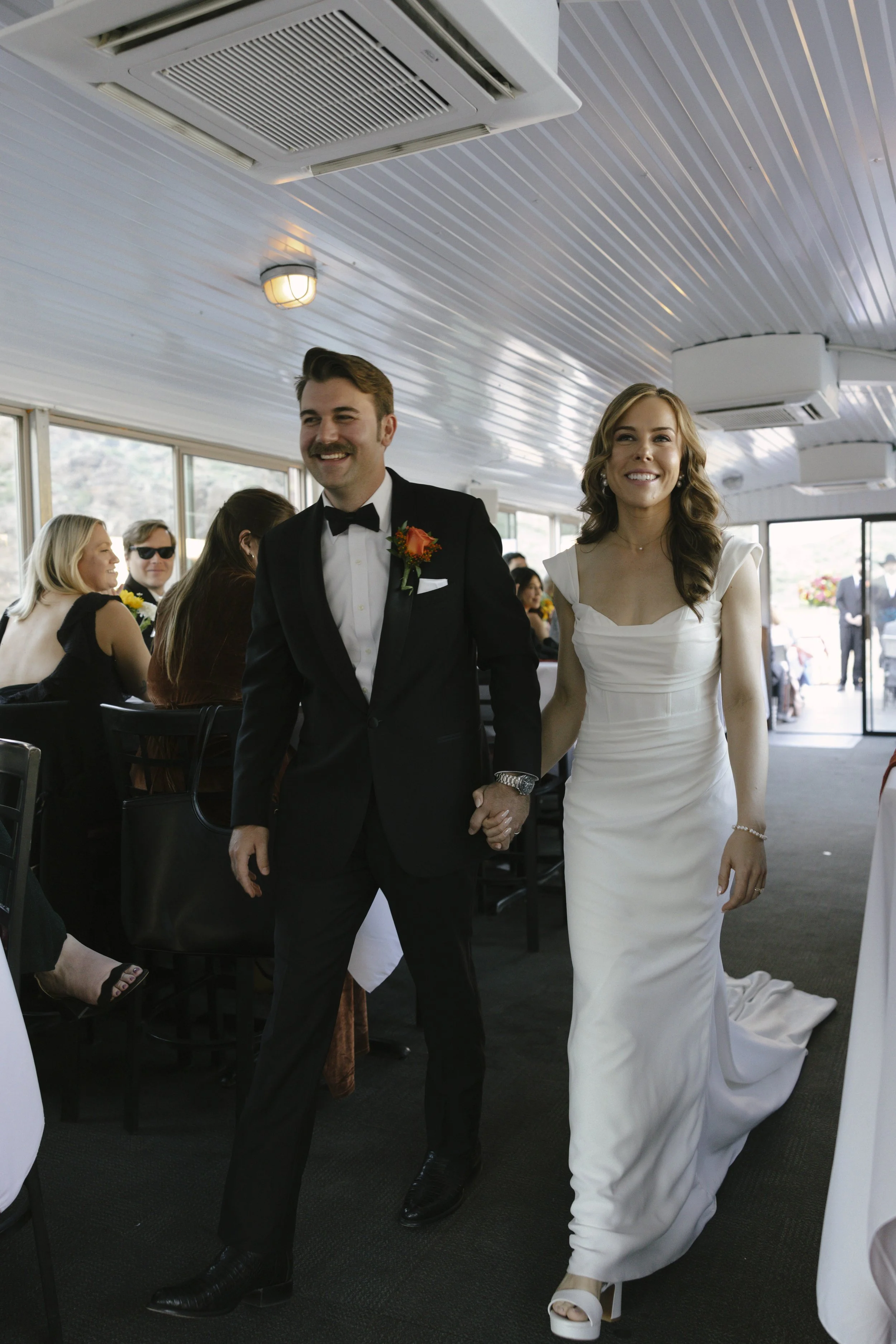With Canyon Lake’s towering desert cliffs surrounding them, the couple exchanged rings and said “I do” aboard the Dolly Steamboat. Surrounded by about 60 of their closest friends and family, the ceremony took place on the deck with breathtaking Arizo