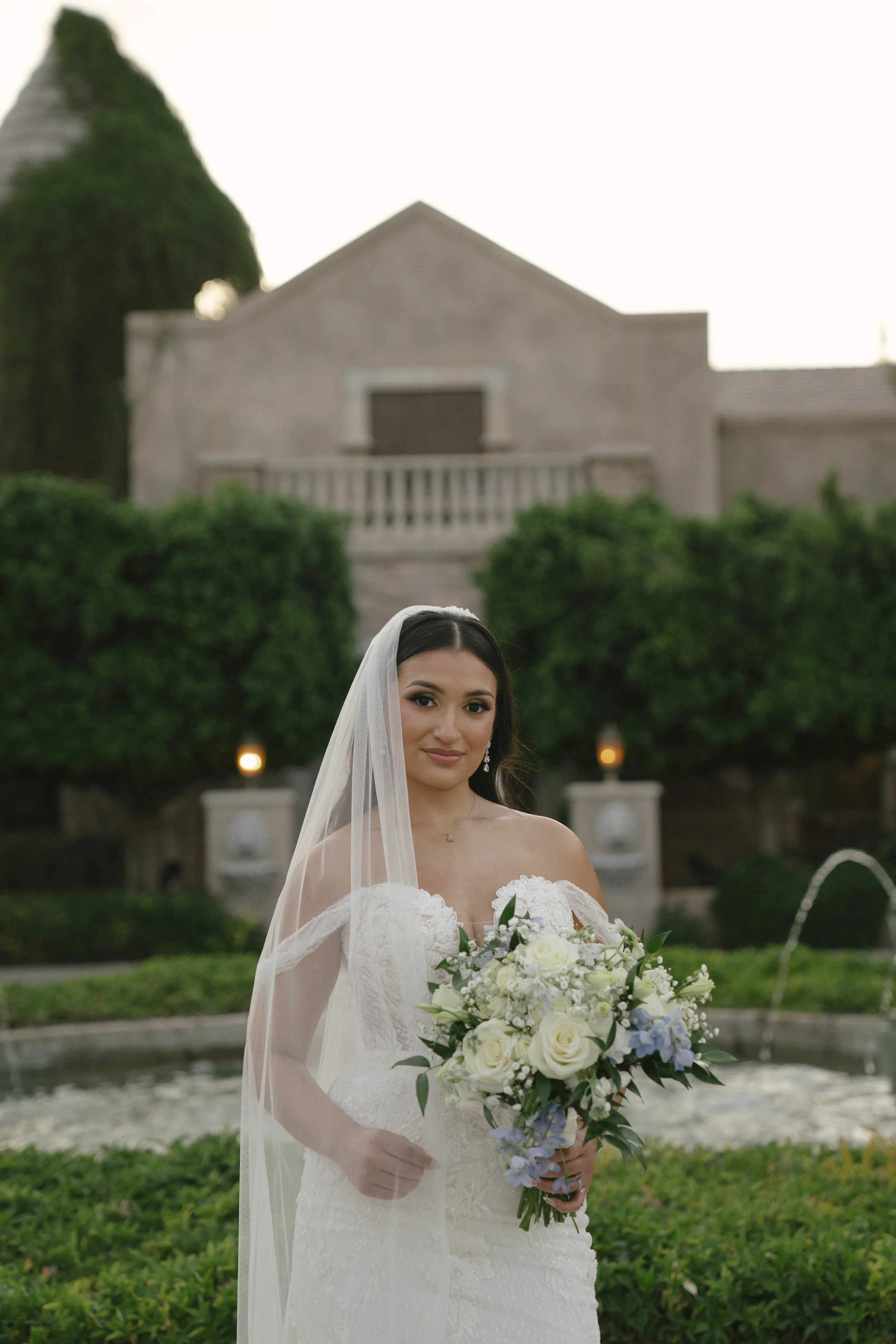 The bride’s solo portraits at Ashley Castle in Chandler, Arizona, were captured through hybrid film and digital photography, highlighting timeless bridal elegance with romantic veil details, graceful movement, and the castle’s stunning courtyard and 
