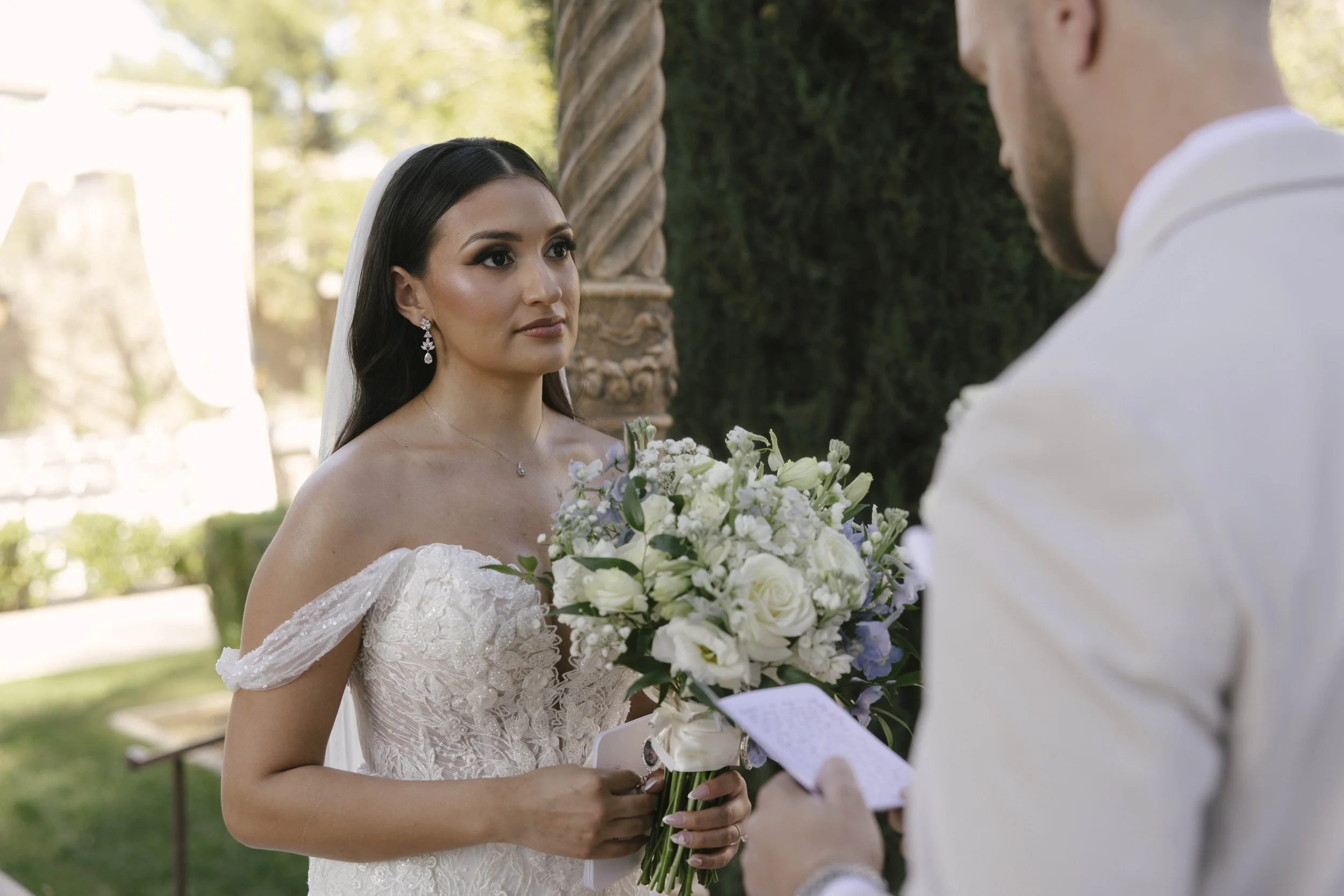 The bride and groom’s first look at Ashley Castle in Chandler, Arizona, unfolded in the venue’s romantic garden gazebo, where hybrid film and digital photography captured their emotional private reveal with timeless elegance, natural light, and intim