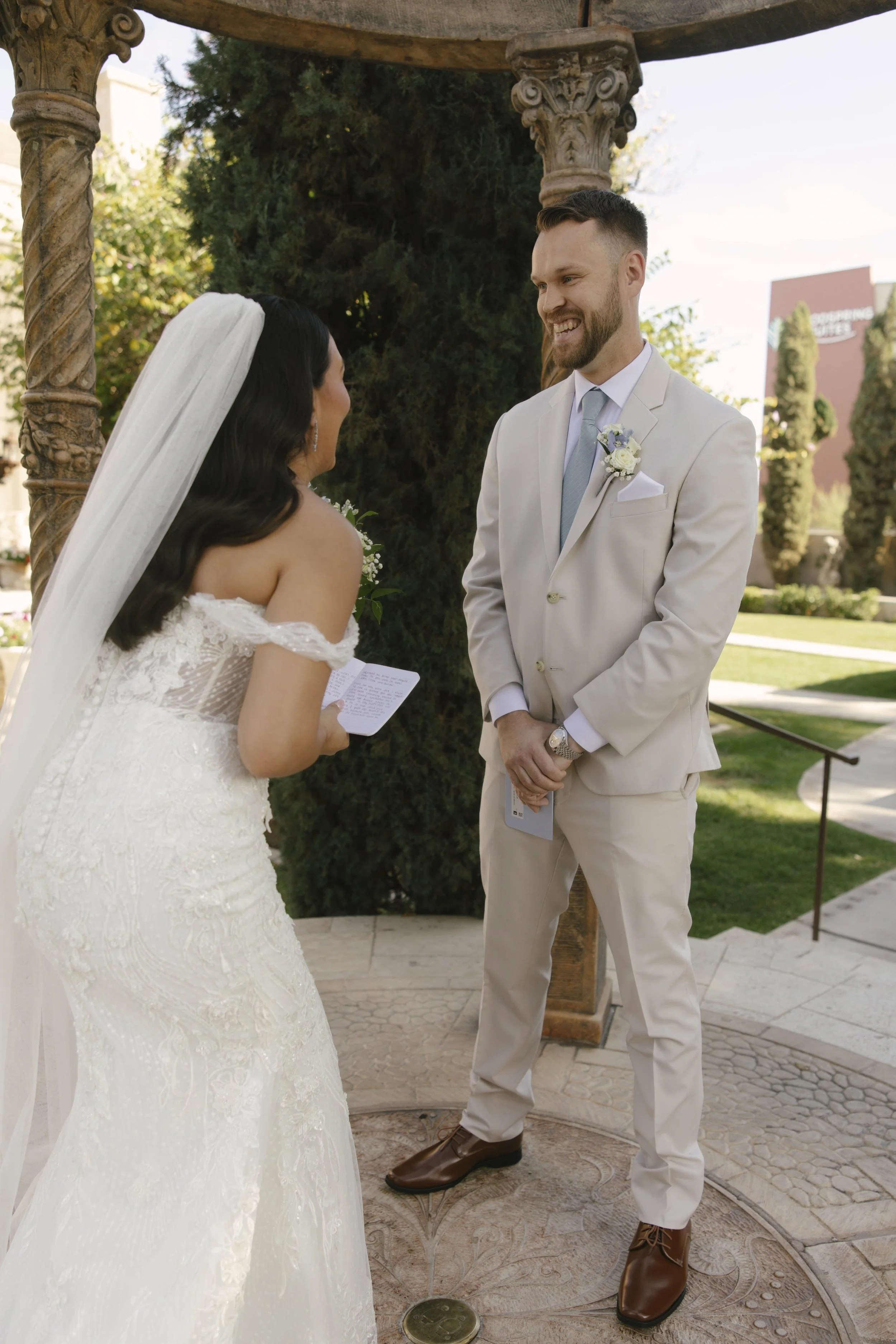 The bride and groom’s first look at Ashley Castle in Chandler, Arizona, unfolded in the venue’s romantic garden gazebo, where hybrid film and digital photography captured their emotional private reveal with timeless elegance, natural light, and intim