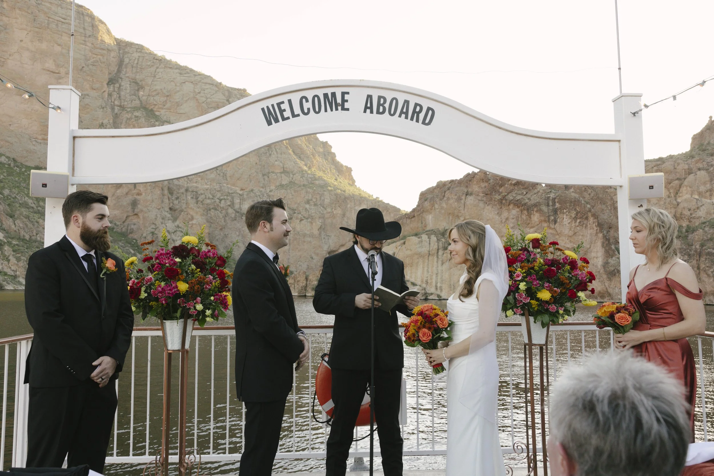 With Canyon Lake’s towering desert cliffs surrounding them, the couple exchanged rings and said “I do” aboard the Dolly Steamboat. Surrounded by about 60 of their closest friends and family, the ceremony took place on the deck with breathtaking Arizo