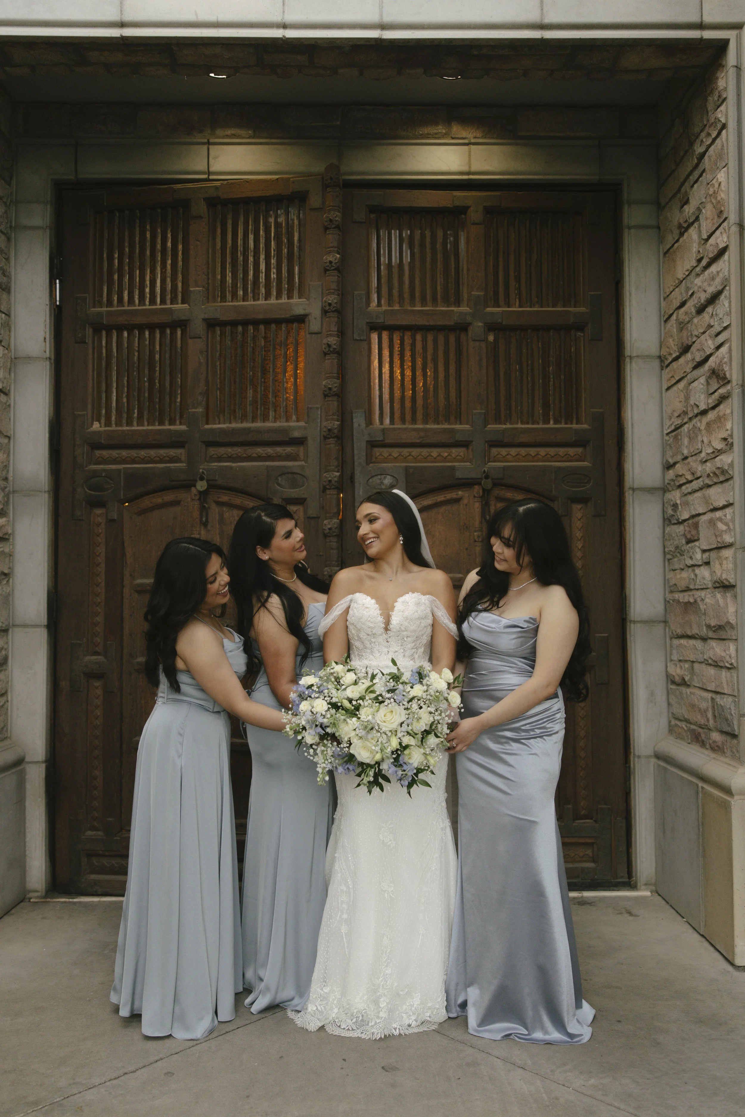 Bridal portraits at Ashley Castle in Chandler, Arizona, were captured through hybrid film and digital photography, showcasing the bride’s timeless elegance alongside her bridesmaids in the castle’s romantic courtyard gardens with soft evening light a