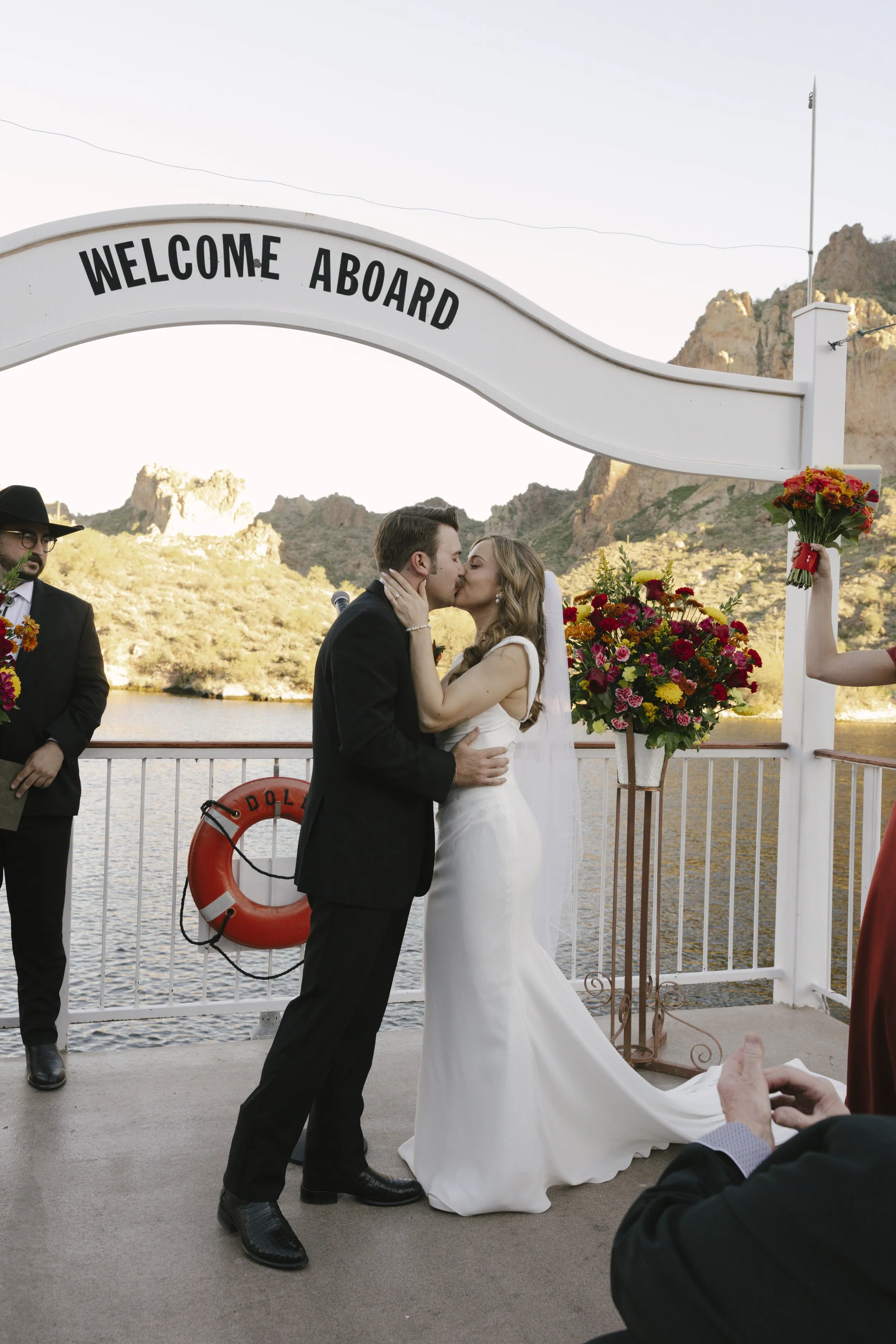 With Canyon Lake’s towering desert cliffs surrounding them, the couple exchanged rings and said “I do” aboard the Dolly Steamboat. Surrounded by about 60 of their closest friends and family, the ceremony took place on the deck with breathtaking Arizo