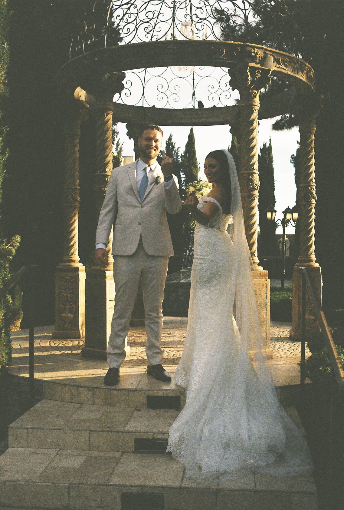 The bride and groom’s ceremony at Ashley Castle in Chandler, Arizona, was beautifully documented through hybrid film and digital photography, capturing their vows, ring exchange, and heartfelt moments beneath a romantic floral altar in the castle’s e