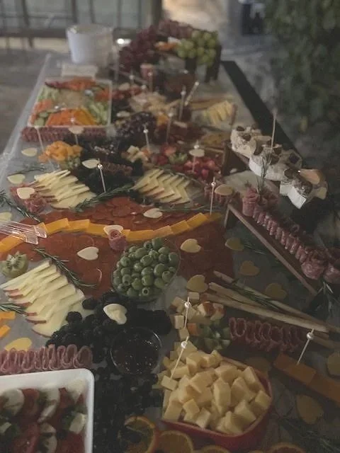 An assortment of cheeses, fruits, and meats arranged on a table for a buffet or party.