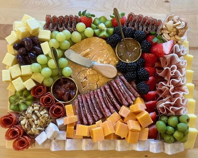 Fruit and cheese platter with dried figs, nuts, honey, and cured meats.