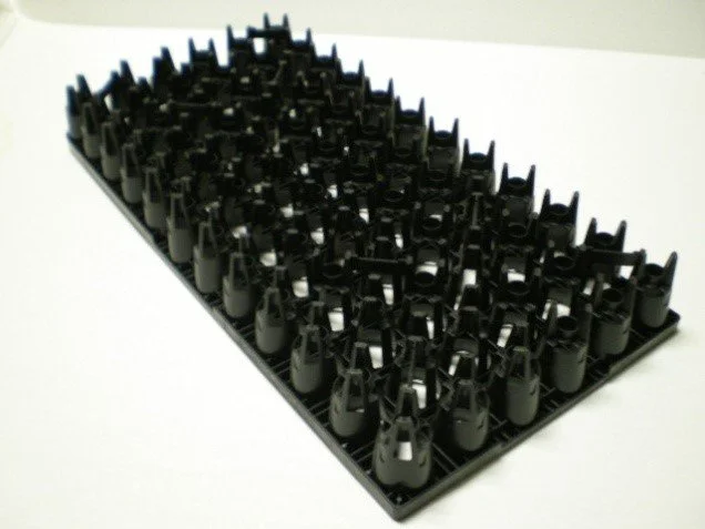 Black electronic keyboard keycap holder with multiple empty keycaps arranged in rows.