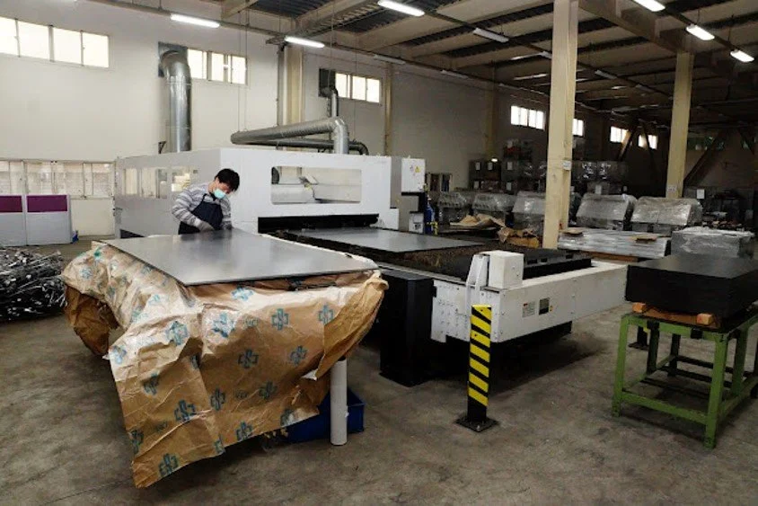 Person working with a large industrial machine in a factory or warehouse.