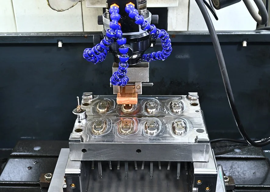 A machine with copper element and blue flexible tubing depicting a manufacturing or testing process.