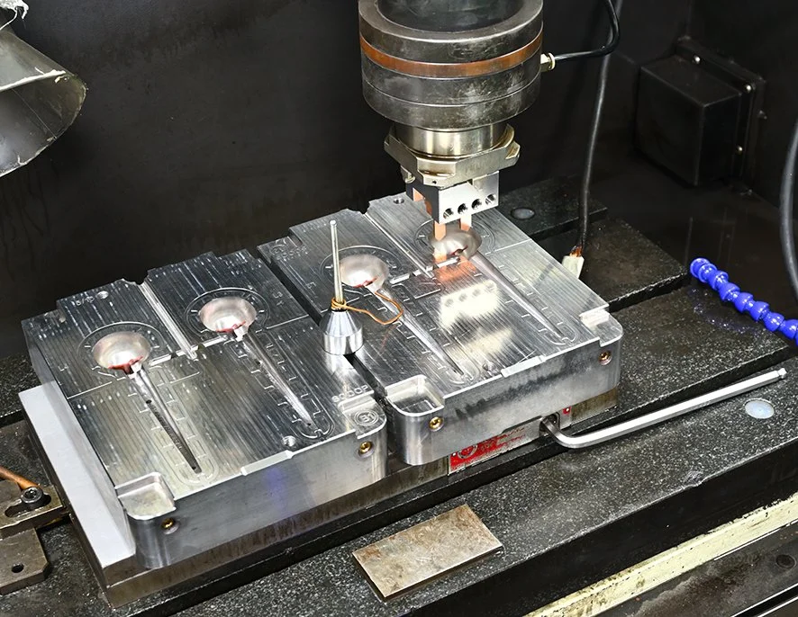Metal CNC machining tool cutting into a metallic block.