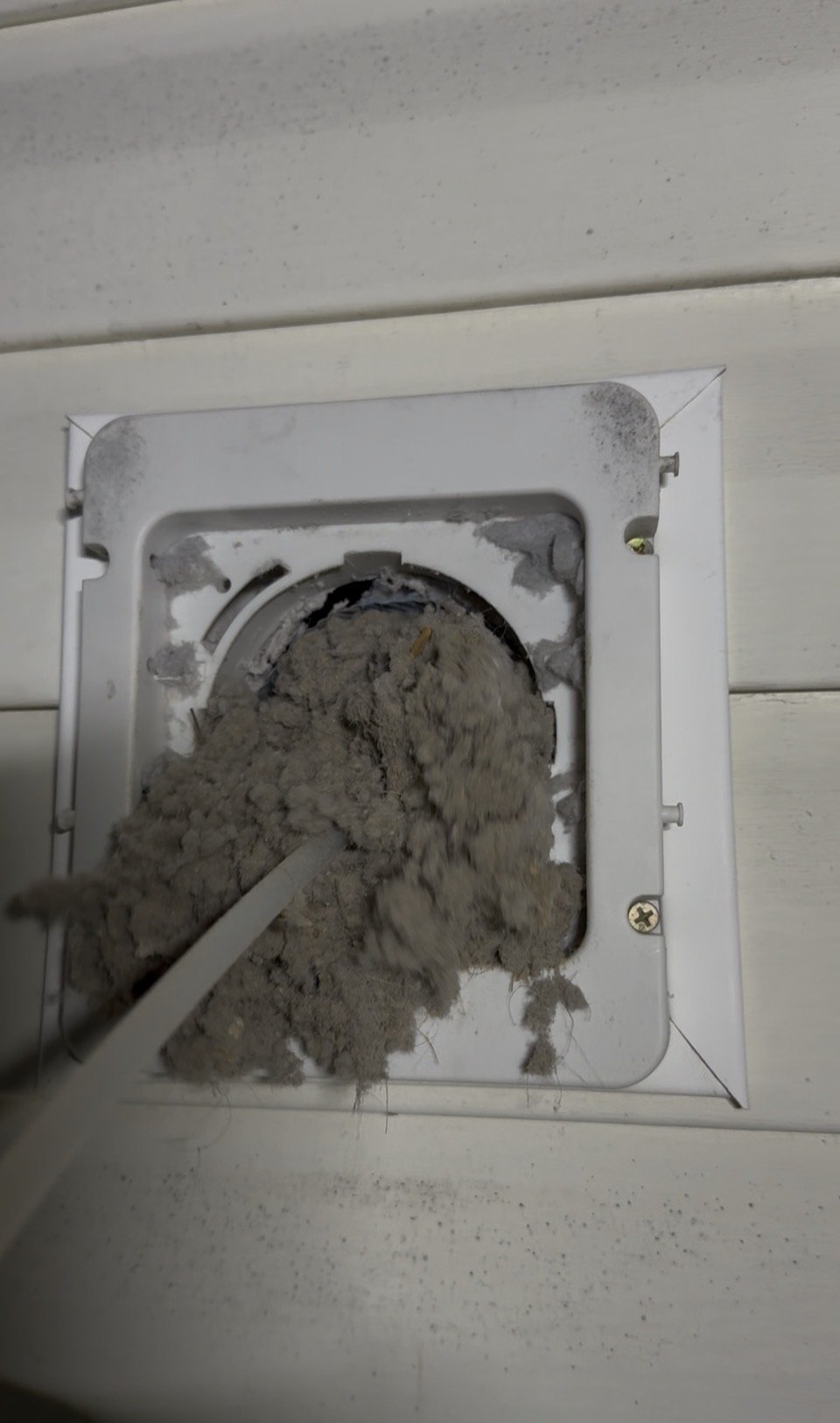 A bunch of lint being removed from a dryer vent. 