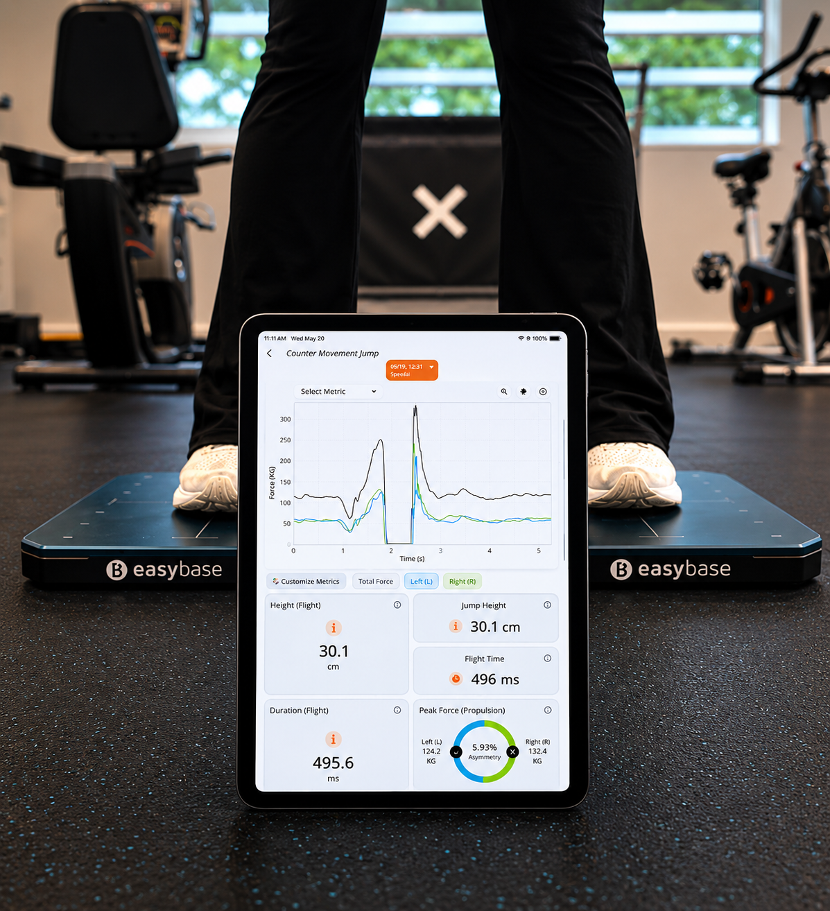 Tablet displaying athlete performance data positioned on force plate testing equipment.