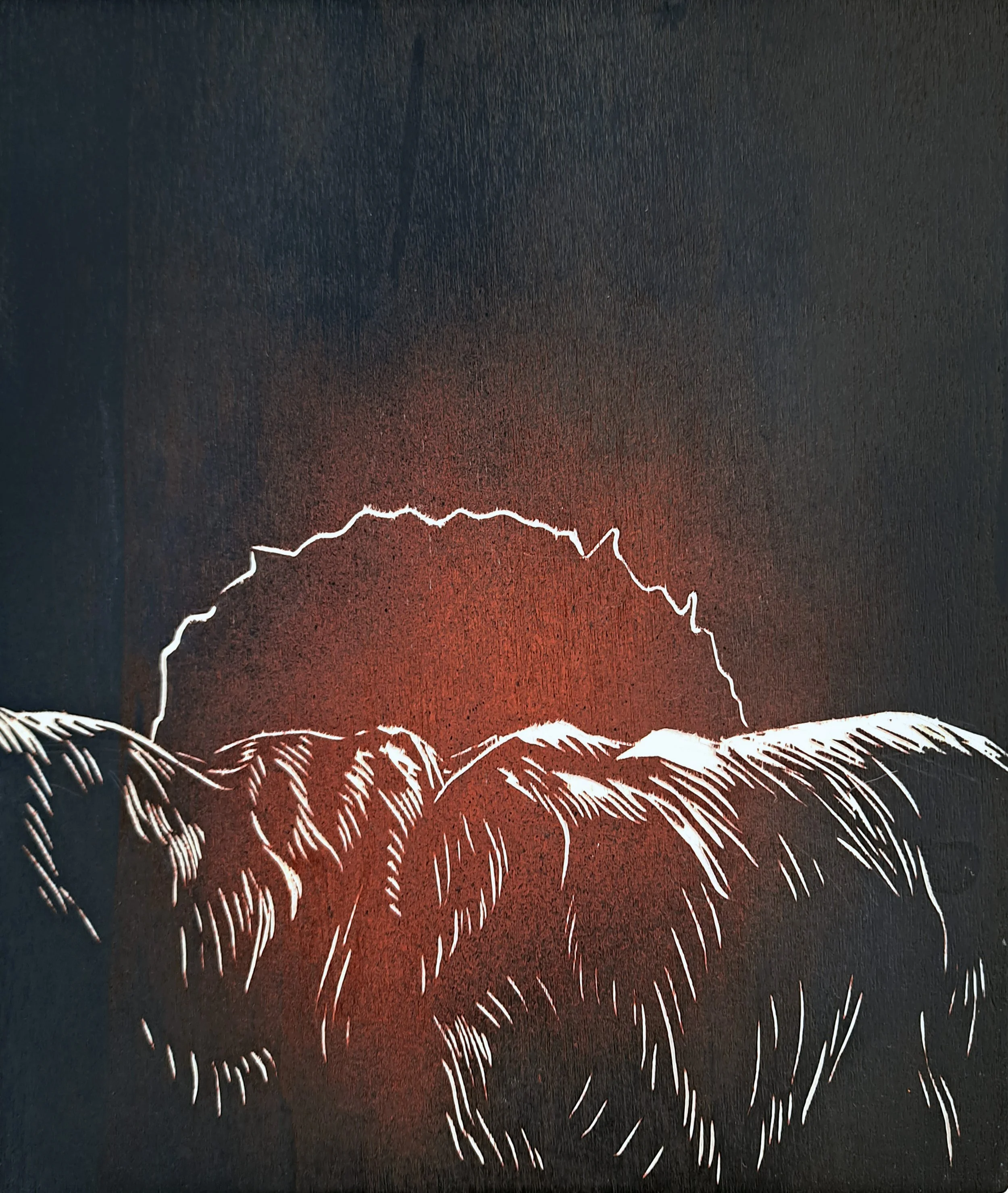 A black and white wood carving of a back with a red glow emanating from the center.