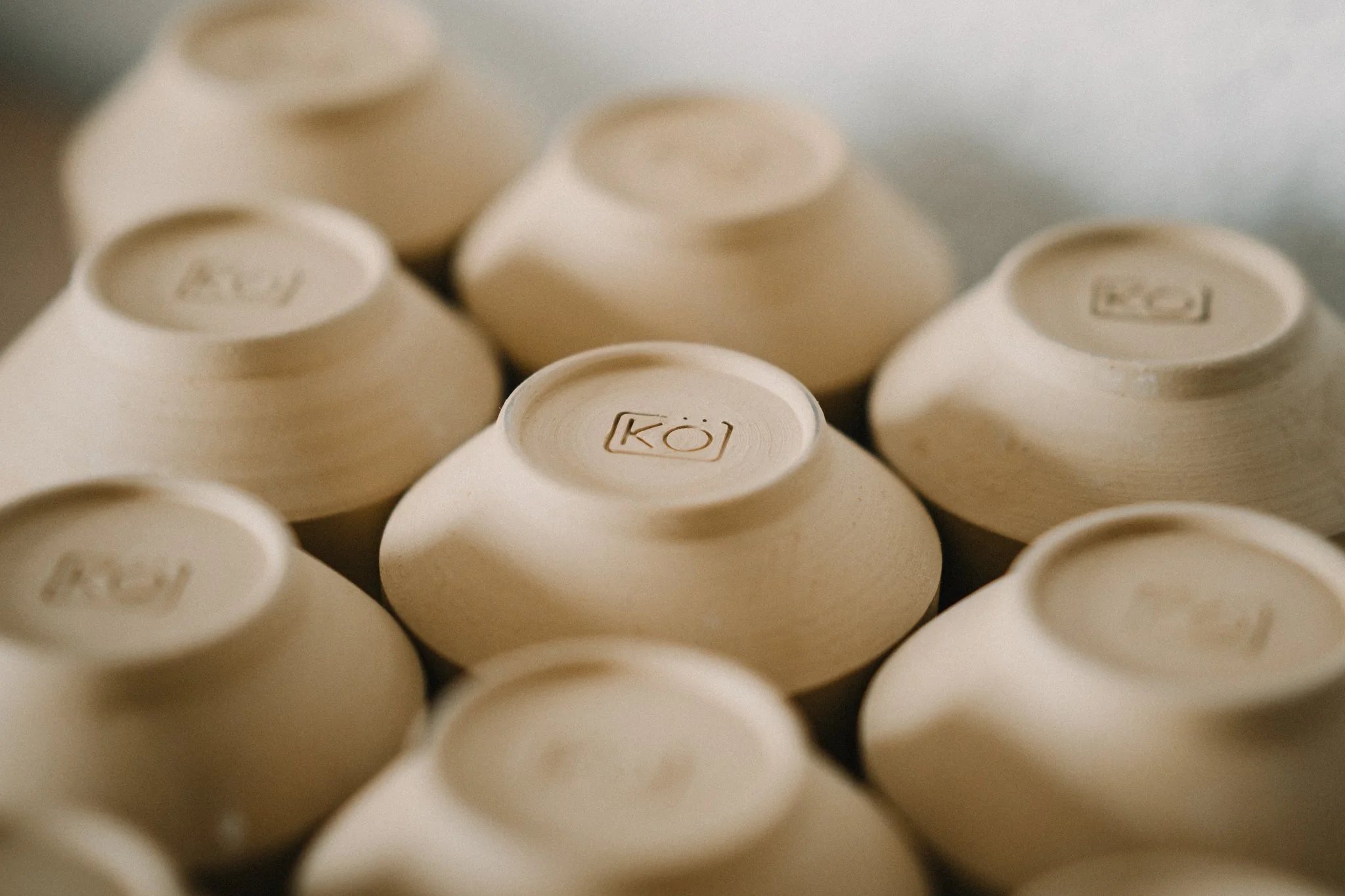 Close-up image of multiple white eggs, some marked with a logo that resembles a camera icon.