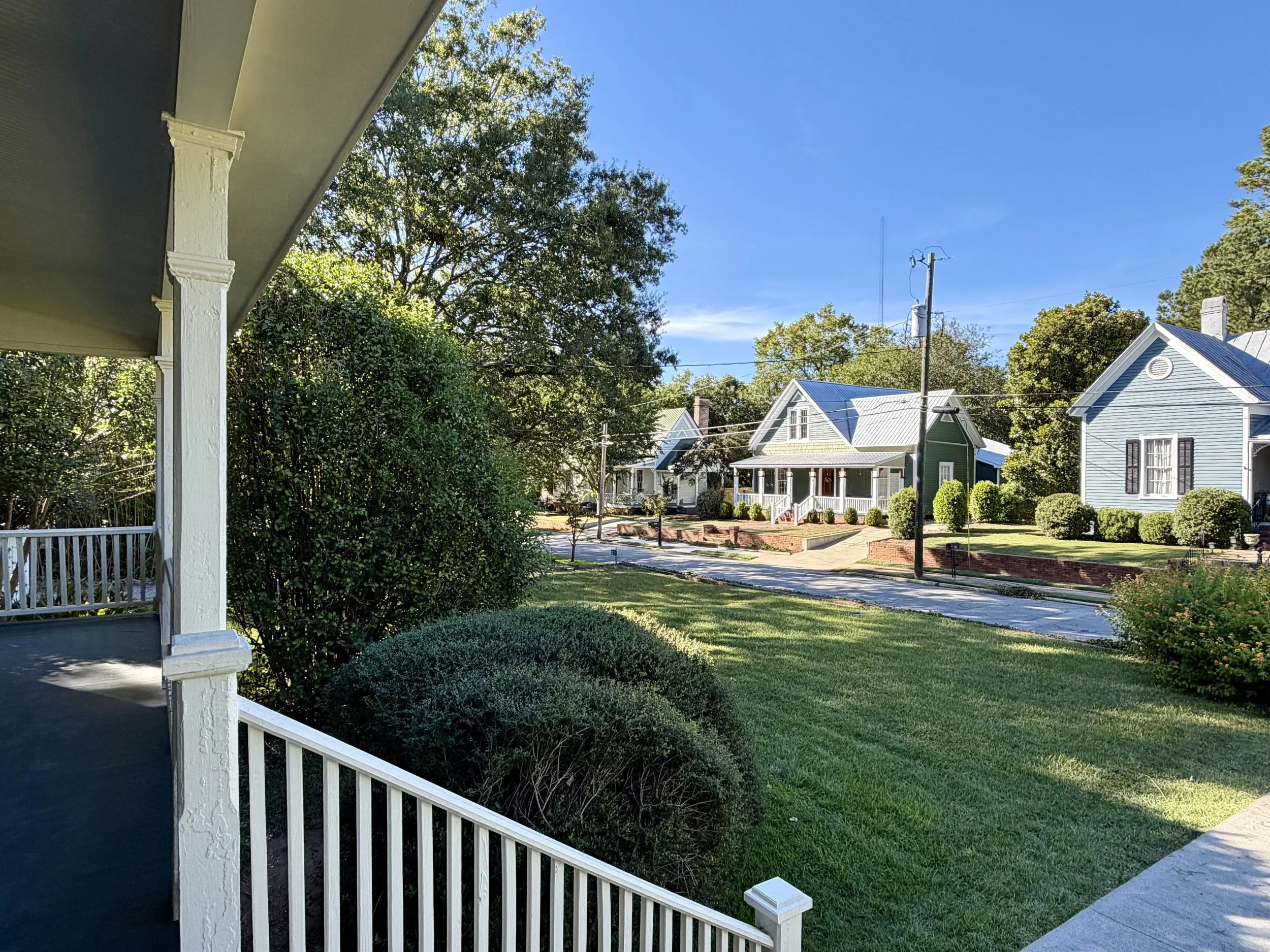 View from the covered front porch at 212 Water Street toward neighboring historic homes in Washington, Georgia.