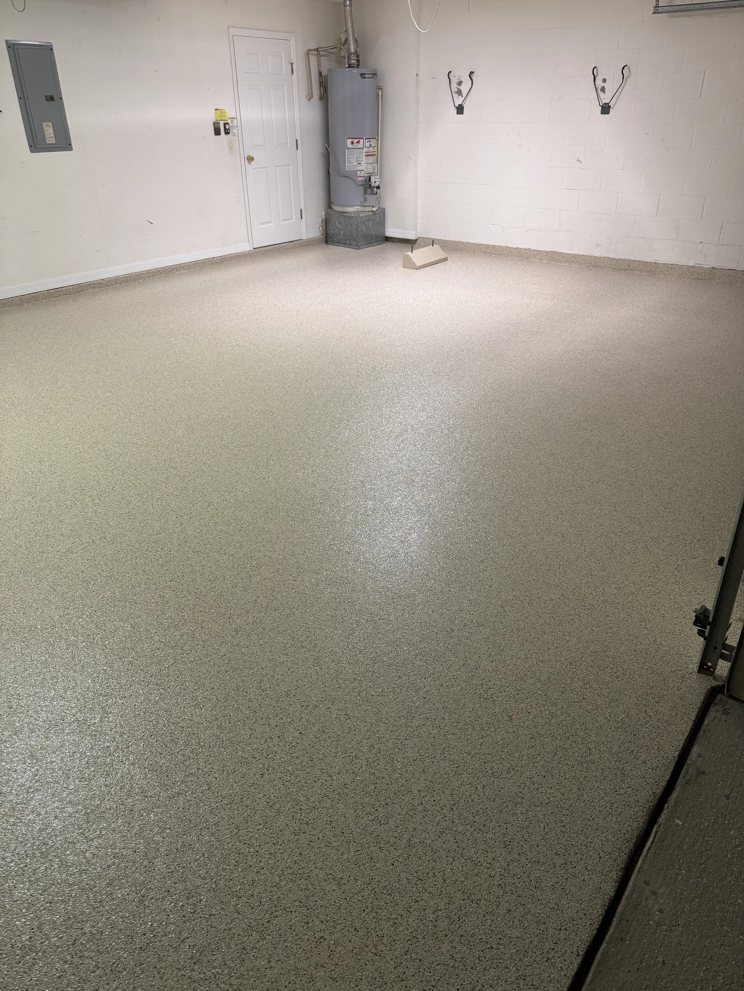 Empty garage with beige speckled epoxy floor, polyapartic, chip system, garage floor, tampa area