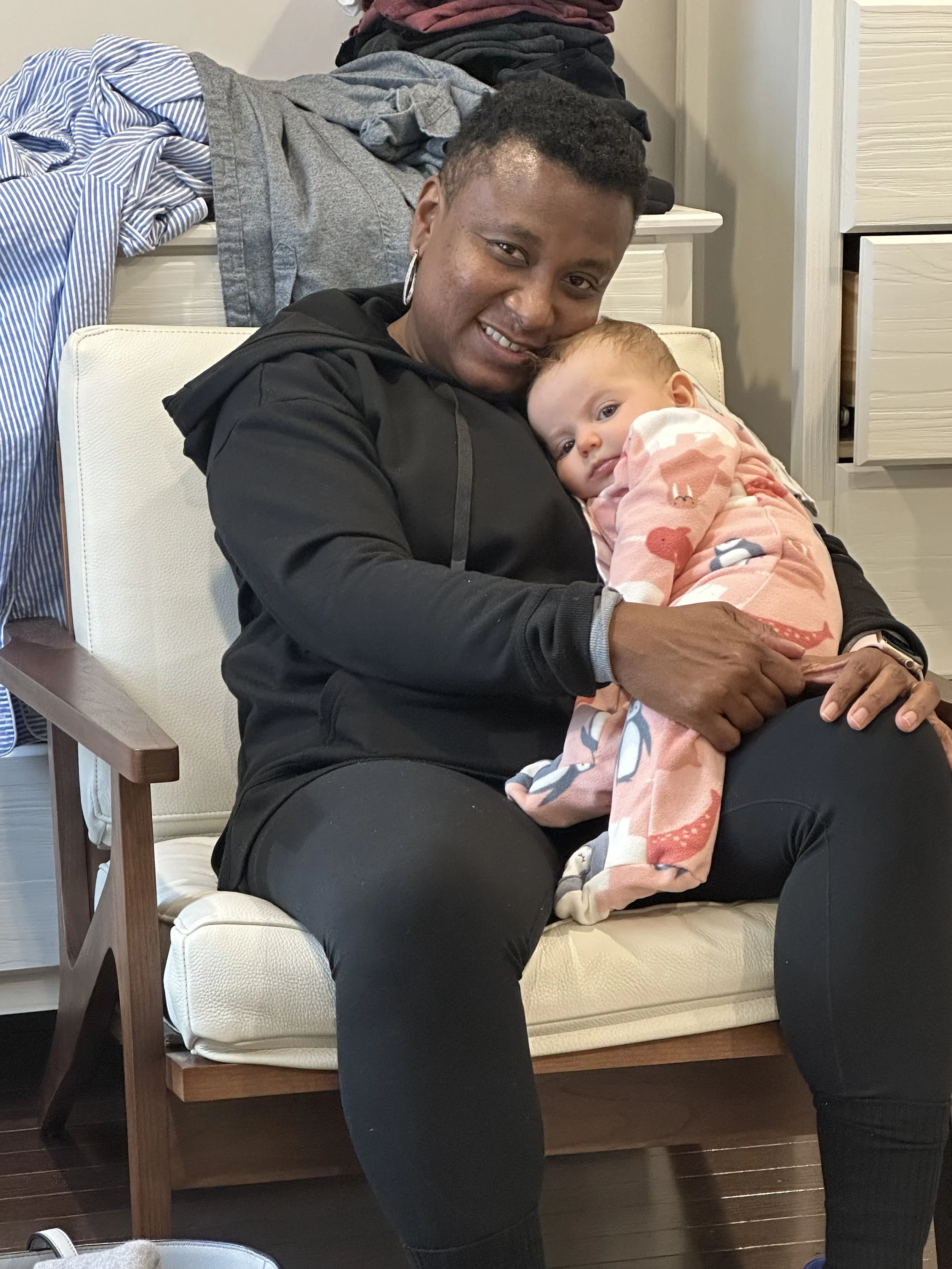 Ria Savoy, postpartum doula and sleep consultant holding newborn baby in Bucks County home.