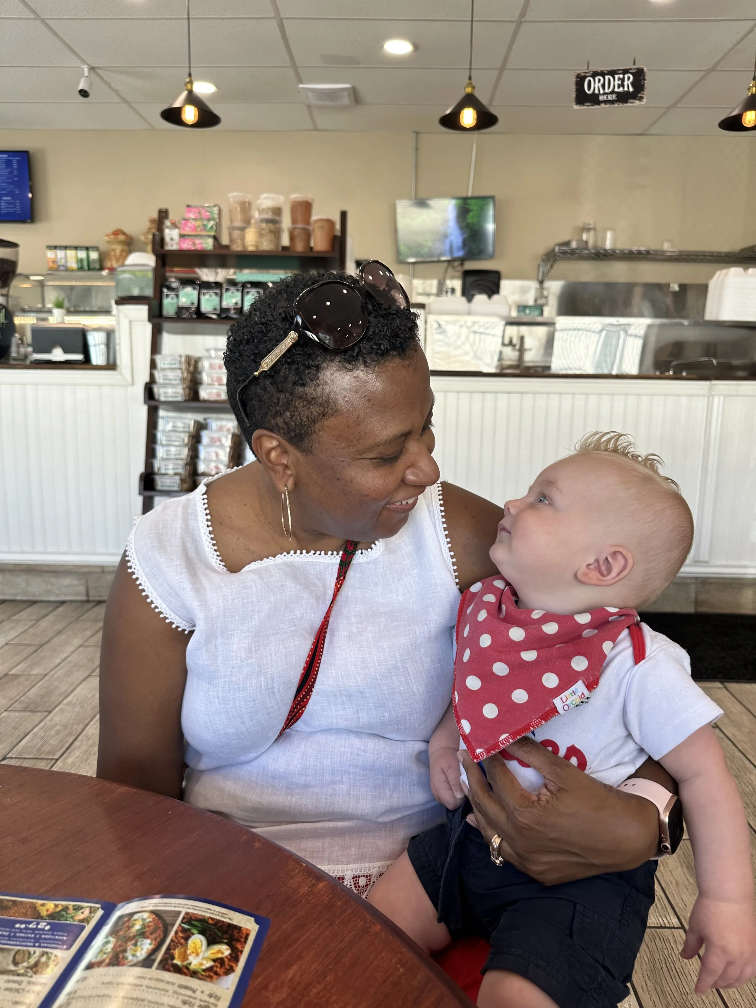Ria Savoy, newborn care specialist, holding baby in a restaurant in Bucks County, PA.