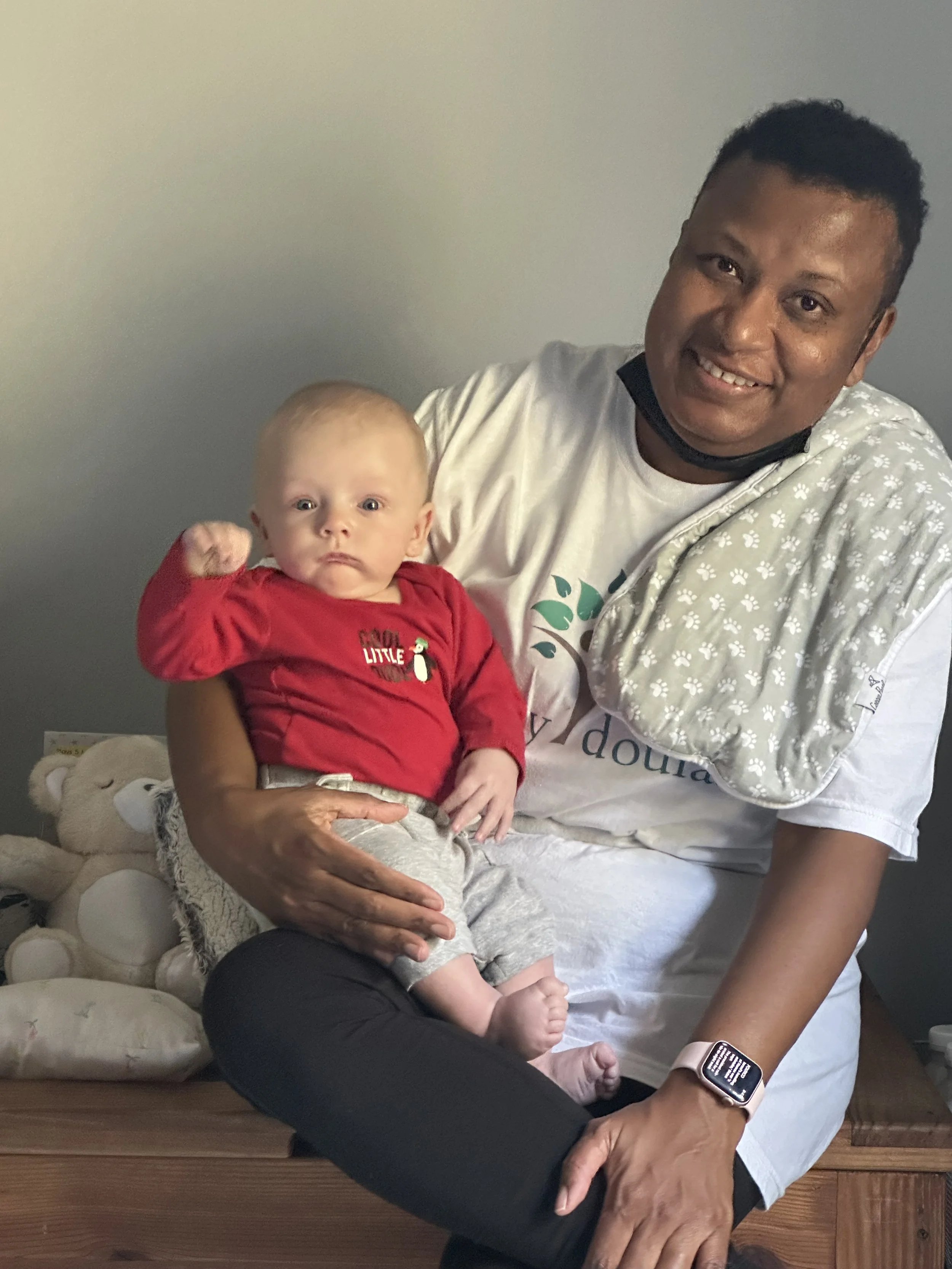 Ria Savoy, birth and postpartum doula holding a newborn baby in Philadelphia.