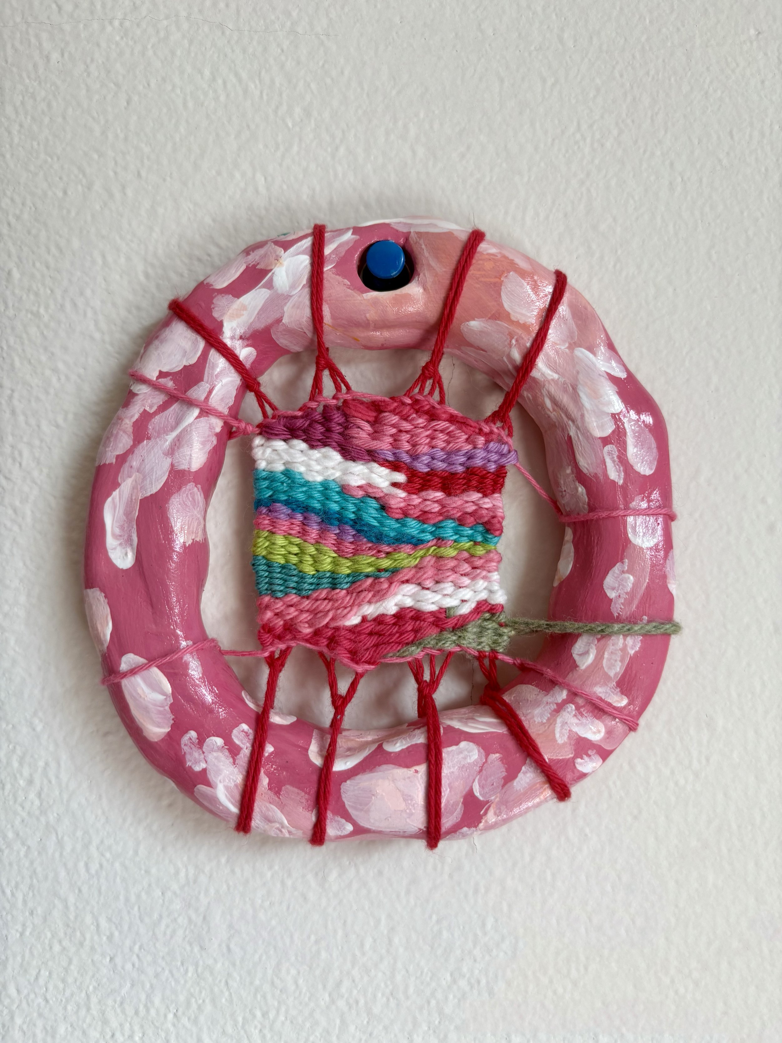 "A romantic early-evening date at the botanic gardens in Spring." --- Romantique (2025). 4" x 4" x .75". Thread, yarn, clay, acrylic paint, and glue.