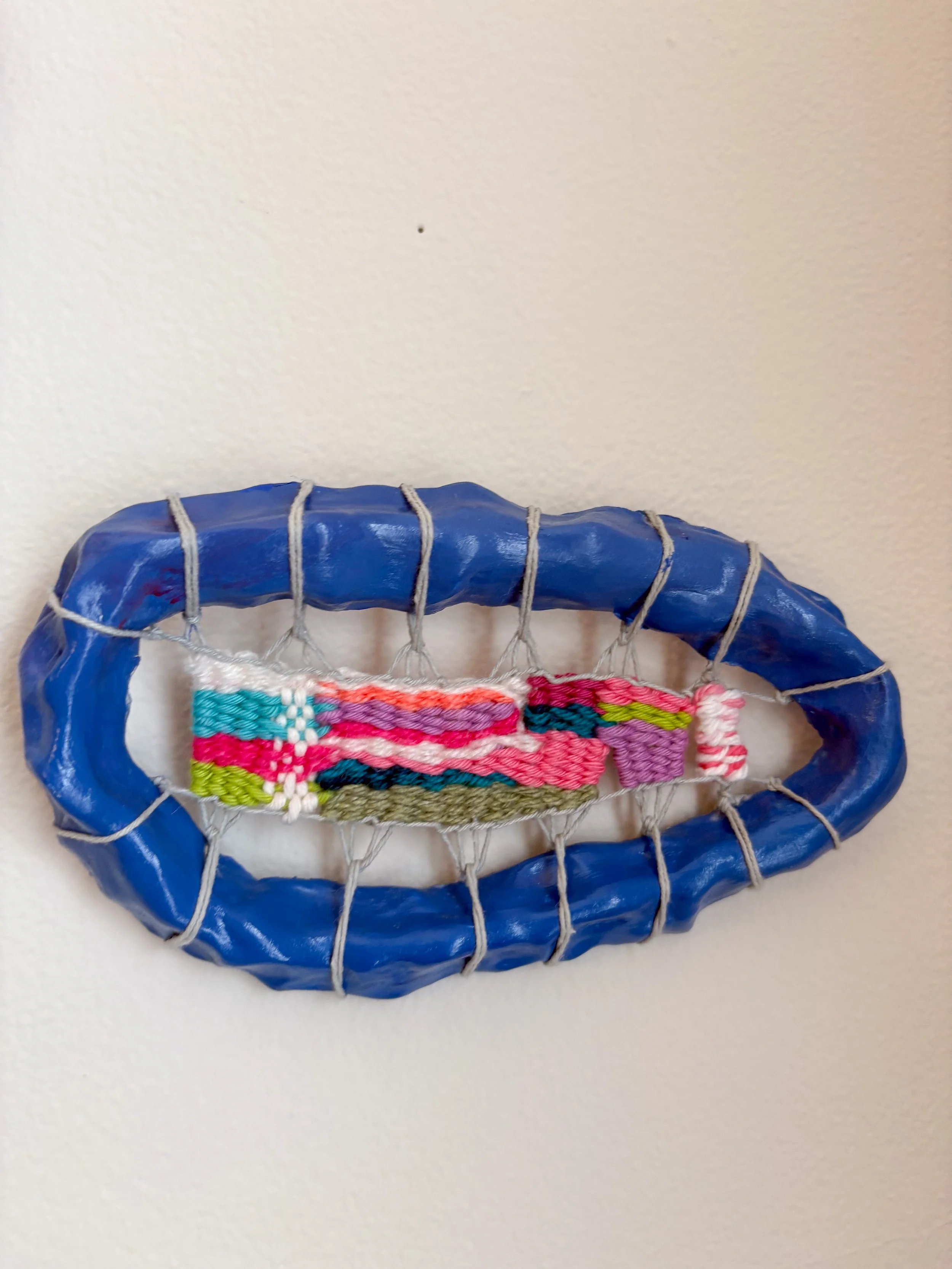 "Staring up at a night sky, finding shapes and colors amongst the stars, a warm mug of butterfly pea flower tea steeping in your hand, resting on the grass." --- Midnight Blue (2025). 6.75" x 4" x 1". Thread, yarn, clay, acrylic paint, and glue.  Ava