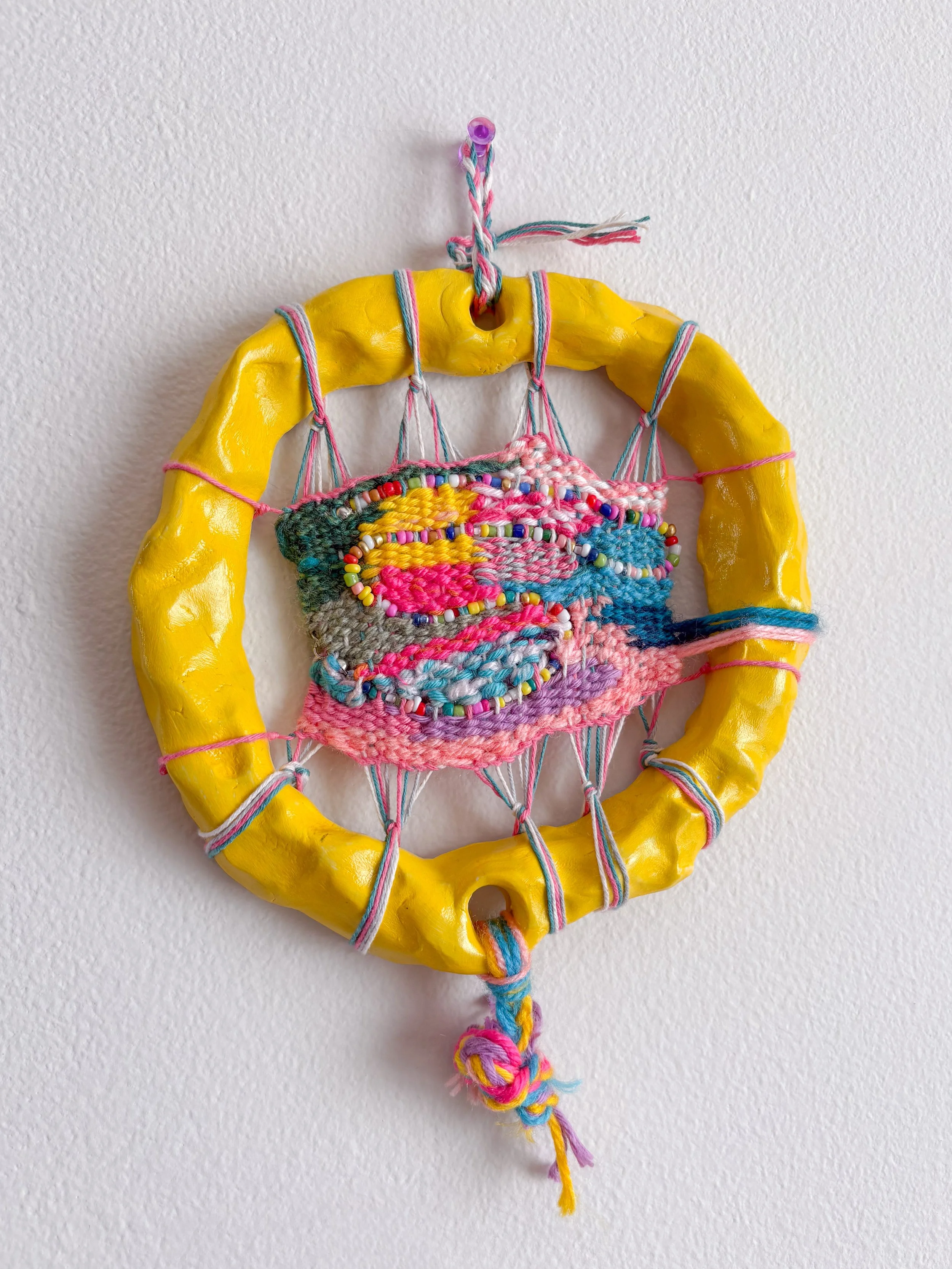 "Trying new things without feeling the pressure of perfection. Creative bursts, inspired ideas, and confidence in experimentation." --- Inspired (2025). 10" x 6.5" x 1". Thread, yarn, clay, acrylic paint, beaded necklace, and glue.