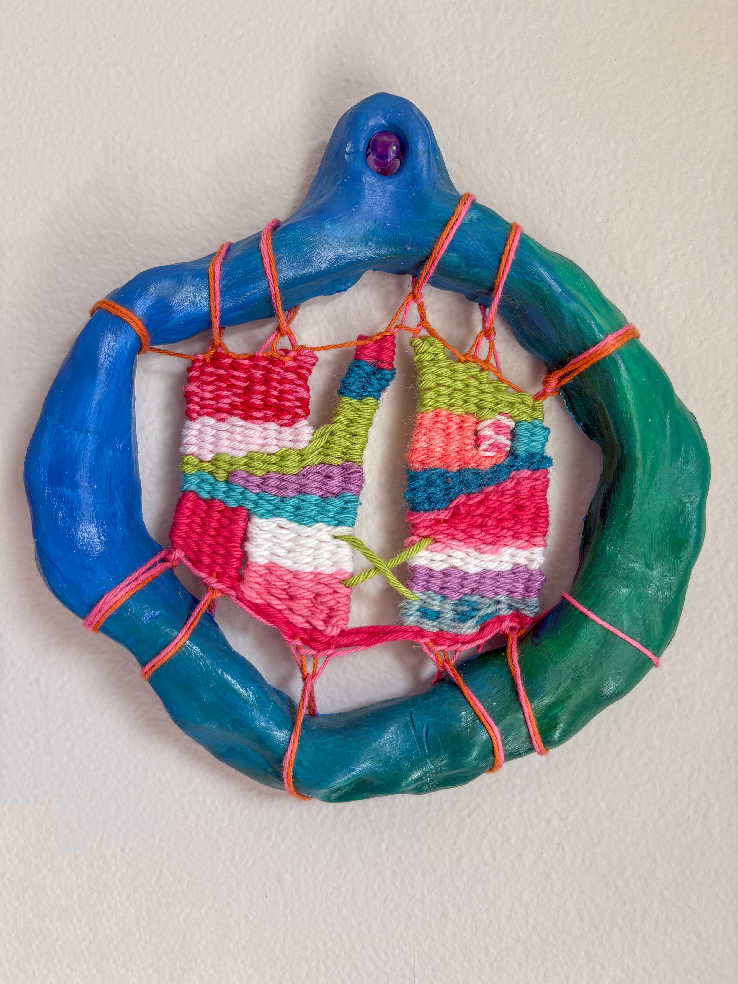 X (2025). 6" x 6.5" x 1". Thread, yarn, clay, acrylic paint, and glue. SOLD.