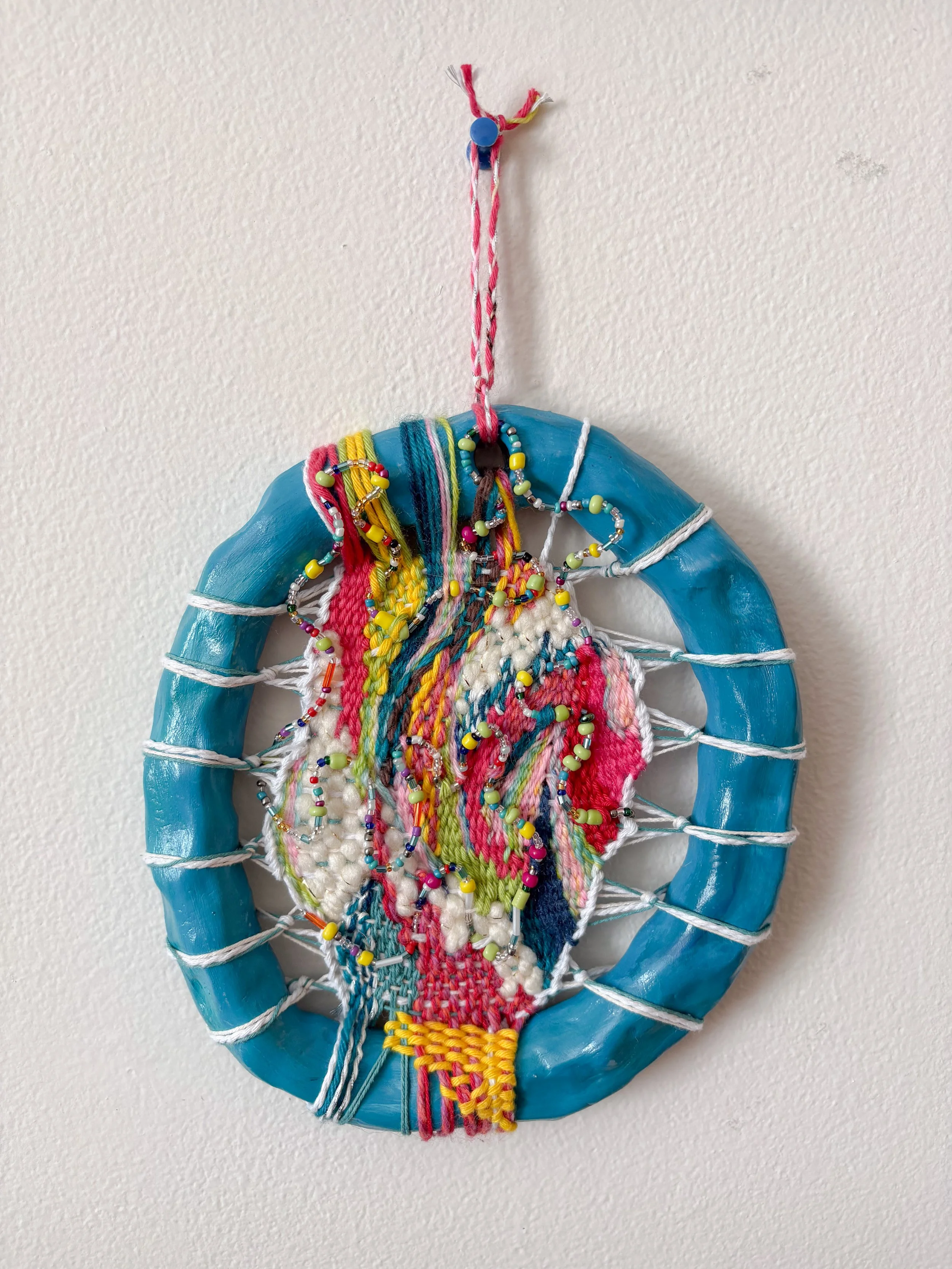 "Laughing after a really good cry. Dancing in nature. Stars after a storm." --- Release (2026). 5" x 7" x 1". Thread, yarn, clay, acrylic paint, wire, beads, and glue.