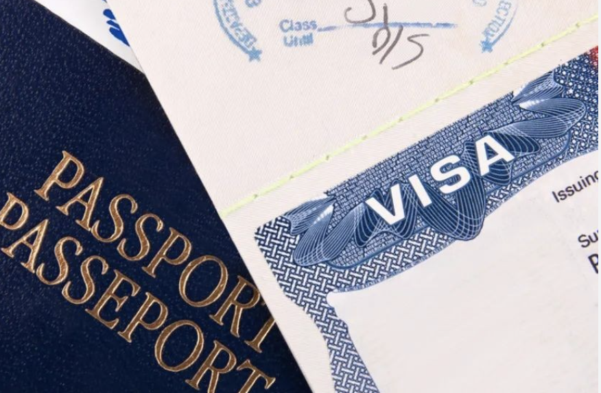 Close-up of a blue passport and a visa stamp on a paper document.