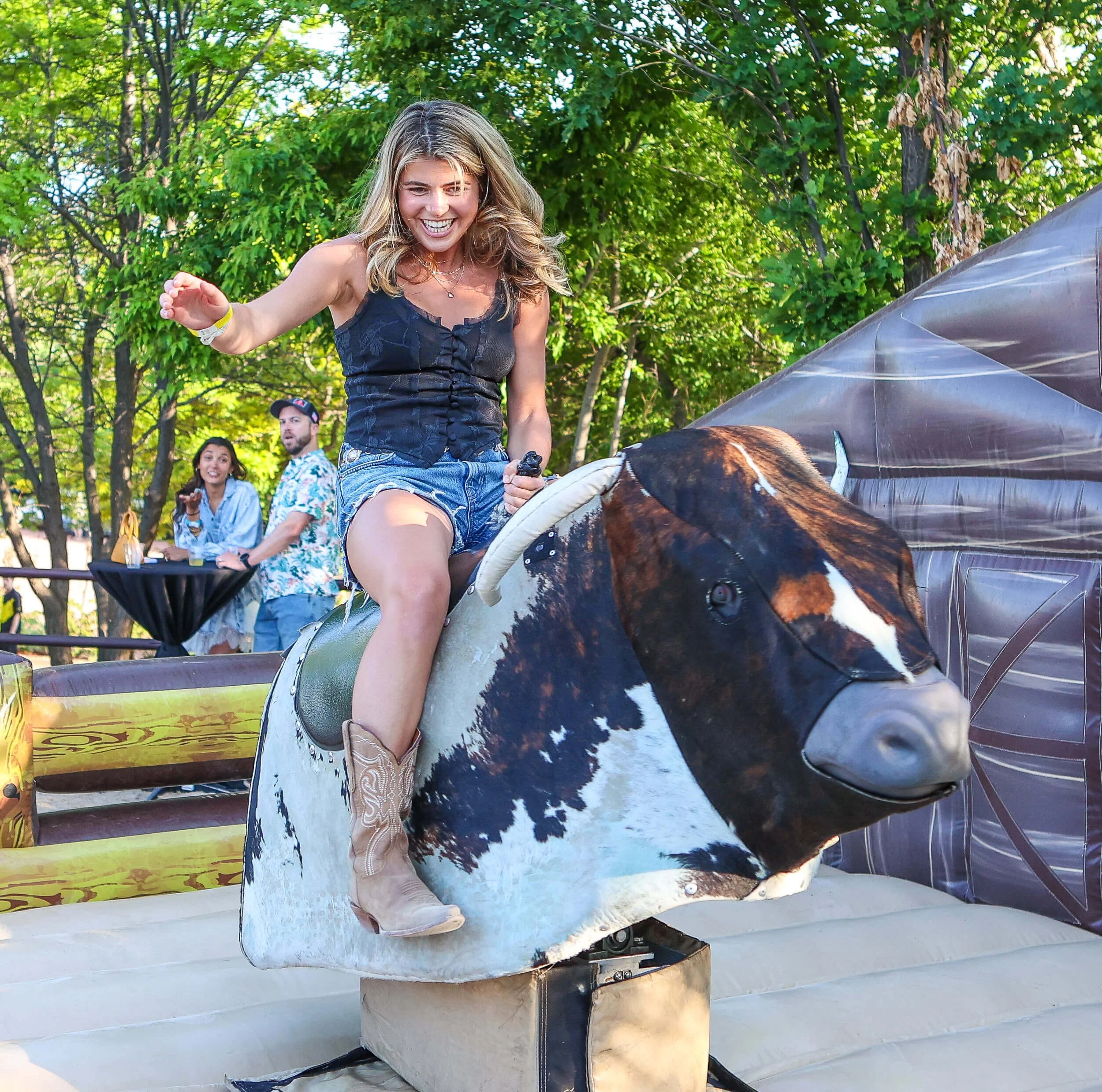 Attendee riding mechanical bull at Denver Barn Party