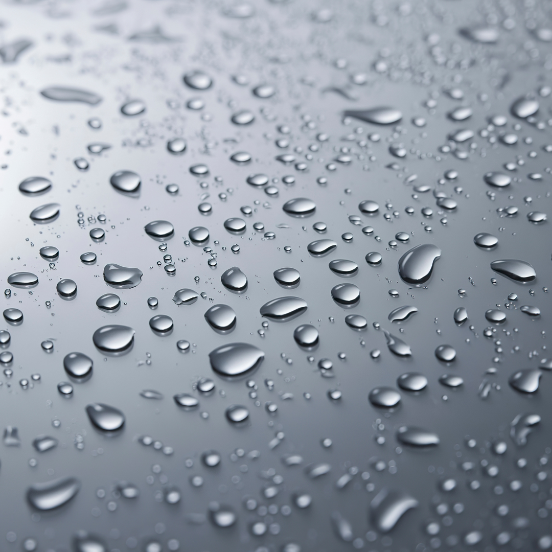 Close-up of water droplets on a metallic surface.