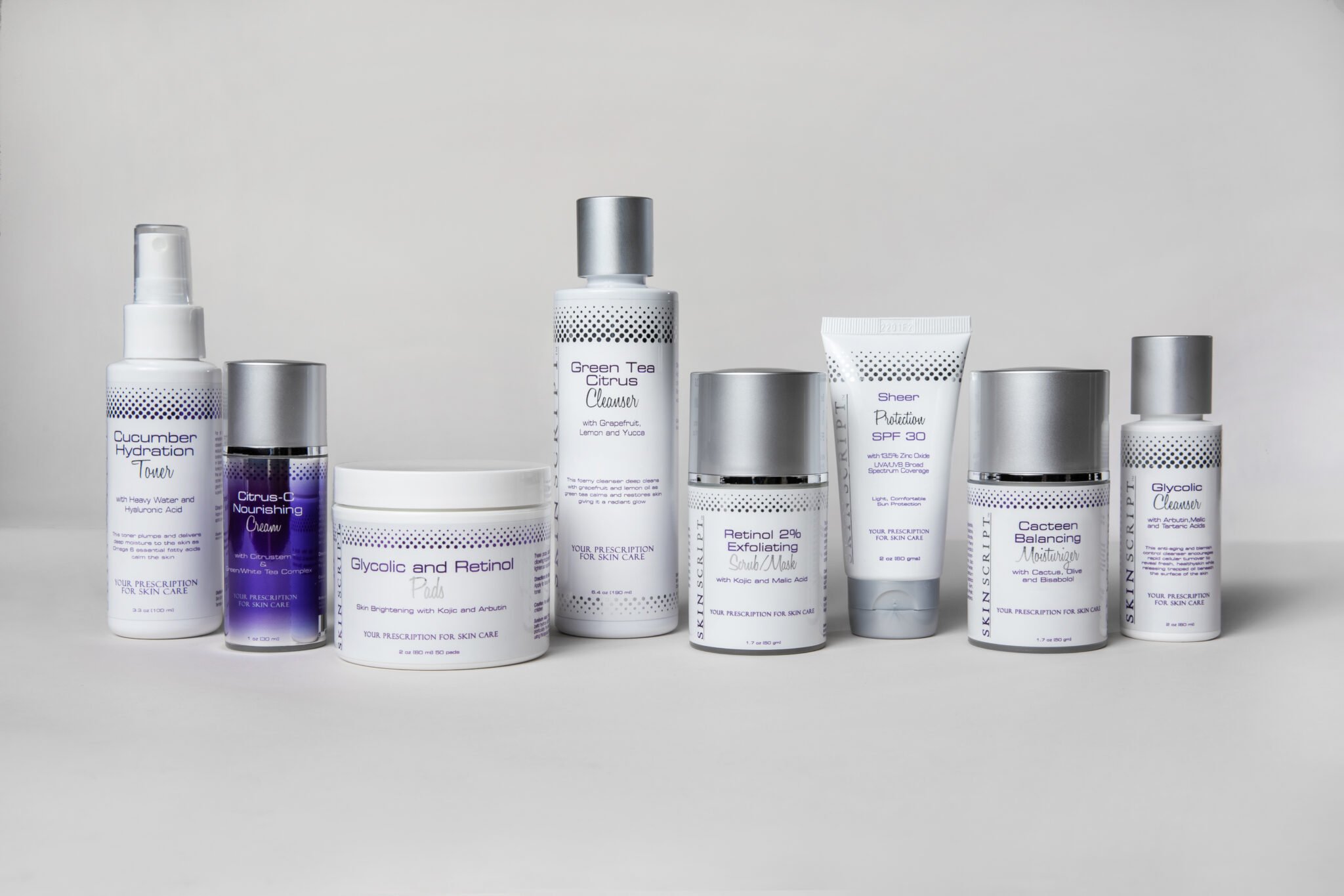 Collection of skincare products including toner, nourishing cream, pads, cleanser, exfoliating scrub/mask, SPF 30 protection, balancing moisturizer, and glycolic cleanser, arranged on a plain surface.