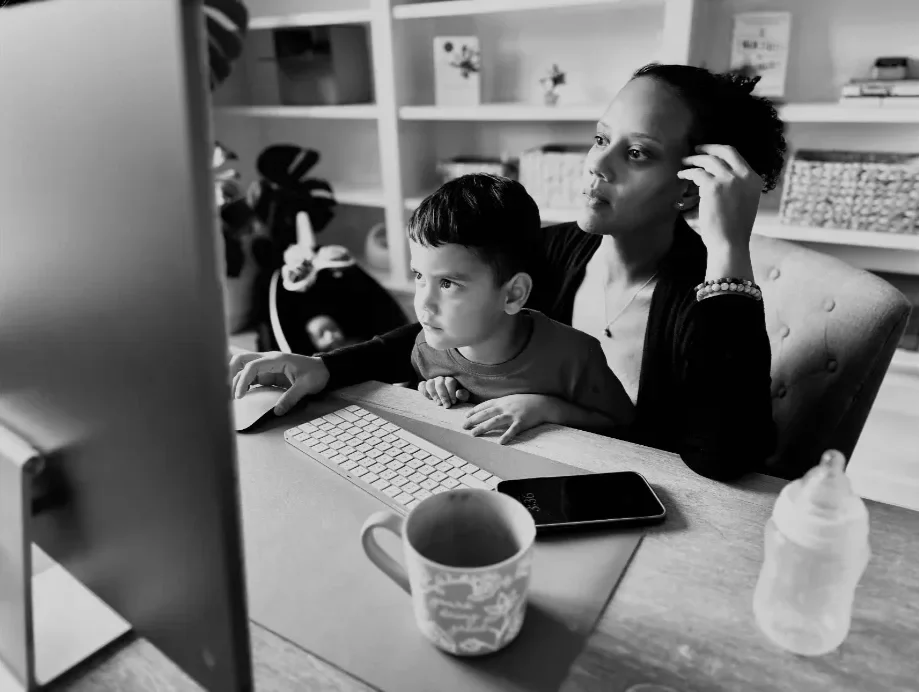 Yari Ising working on the computer with her child in her lap, Founder of My Favorite Cleaning Co. in Lehigh Valley PA