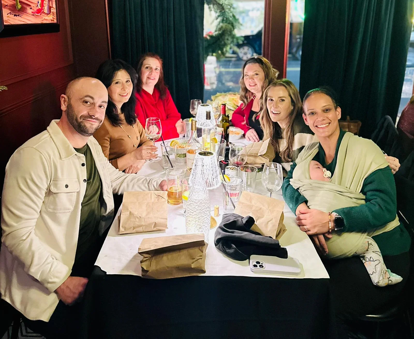 The My Favorite Cleaning Co. team celebrating together at a restaurant, smiling & all looking at the camera from their booth.
