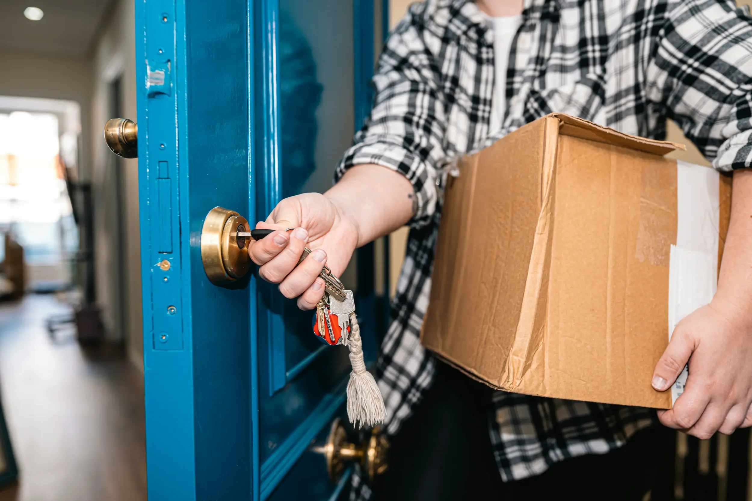 woman opening a blue front door with a key and walking inside to her move in out clean service