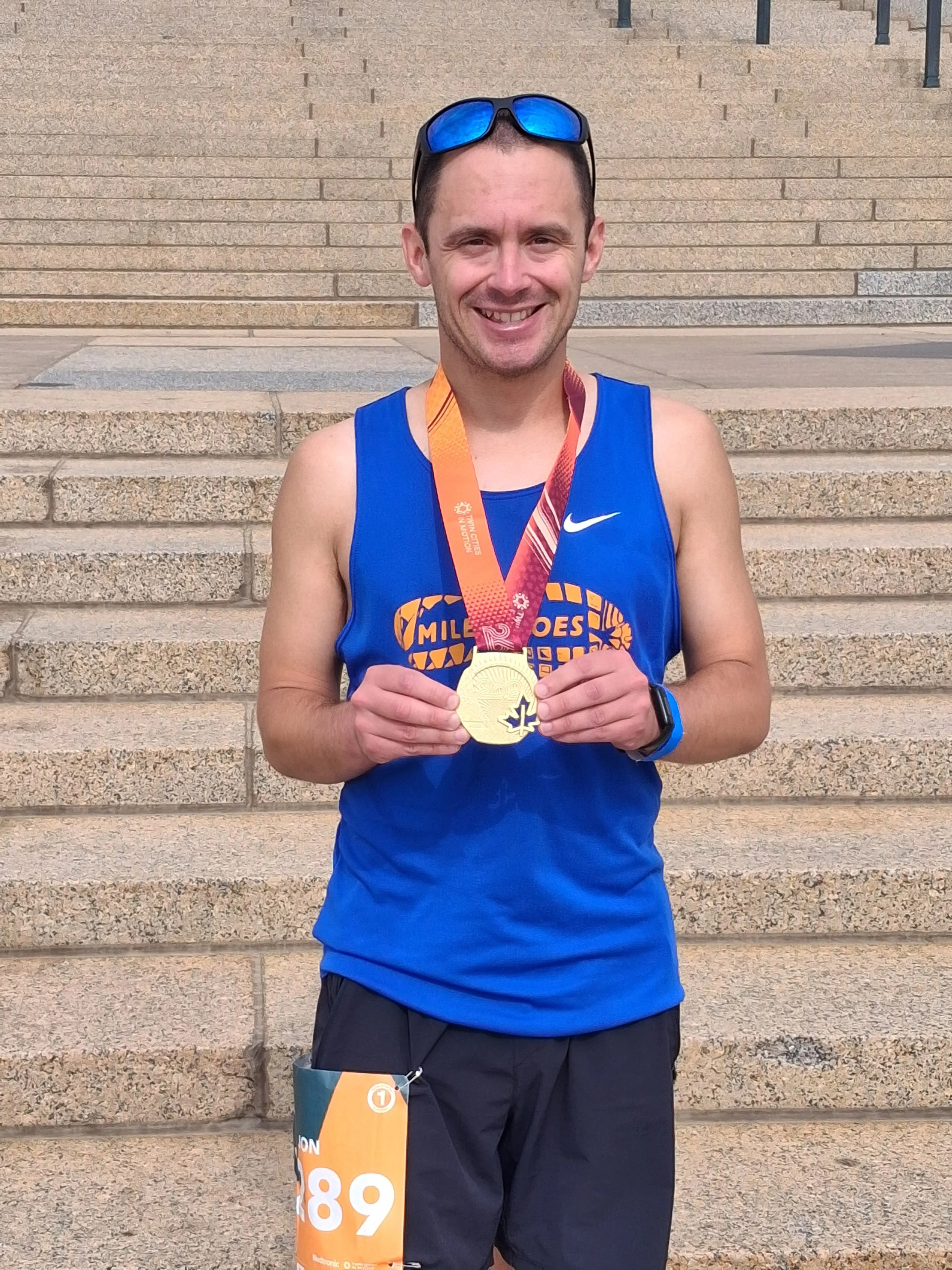 Marathon Runner holding a medal after finishing a race.