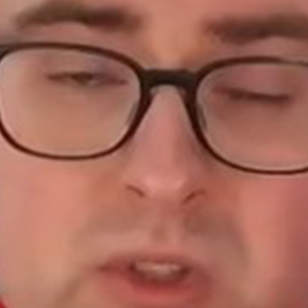 Close-up of a person's face with glasses and eyes closed.