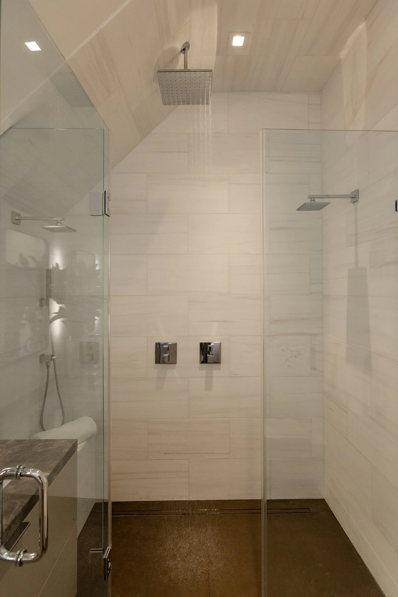 Modern bathroom shower area with a rain shower head and a separate handheld shower.