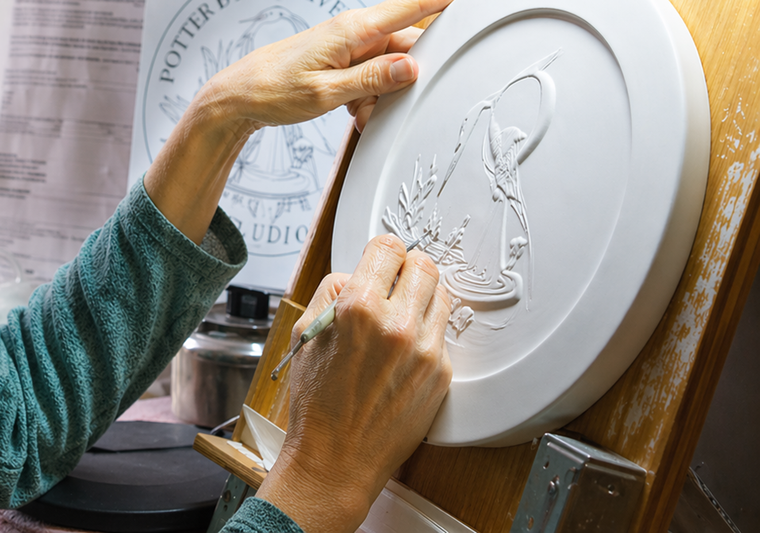Artist sculpting a plaster relief model for coin design, representing John Mercanti's efforts to support emerging talent through the U.S. Mint's Young Artist Program and help inspire future generations of coin and medal designers.